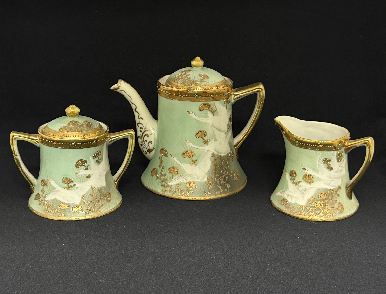 Nippon Tea Set with Flying Geese: Nippon tea pot, creamer, and sugar with jewels and flying geese; ht. teapot 6 1/2". CONDITION: no chips, cracks, repairs, or material defects found, Jaremos attempts to call any material flaw that aff