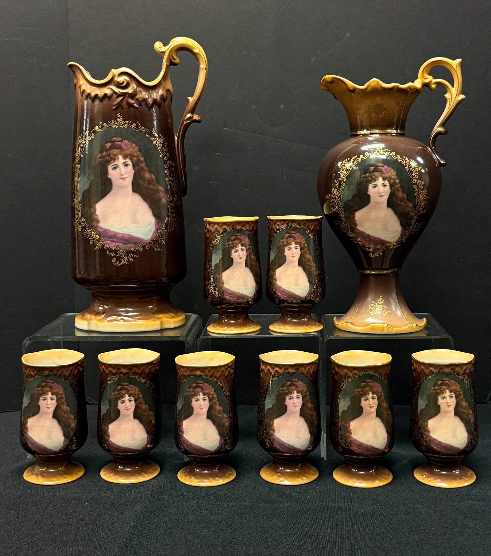 10 Jungfrau Porcelain Items: Grouping of Jungfrau porcelain, two pitchers and 8 tumblers; tallest ht. 14". CONDITION: no chips, cracks, repairs, or material defects found, Jaremos attempts to call any material flaw that affects t