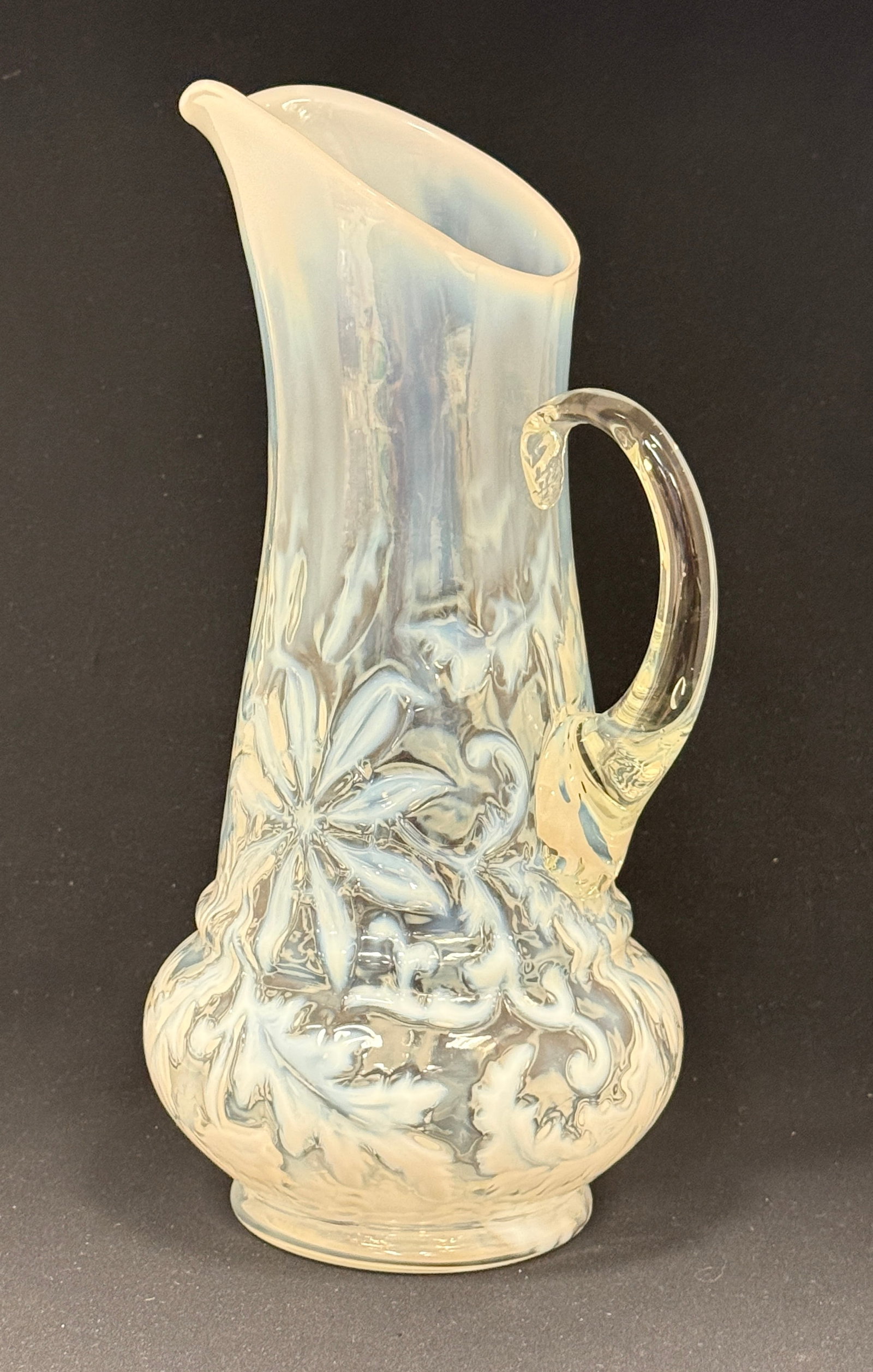 Opalescent Poinsettia Tankard: Opalescent white poinsettia tankard; ht. 13". CONDITION: no chips, cracks, repairs, or material defects found, Jaremos attempts to call any material flaw that affects the price, but minor scratches an