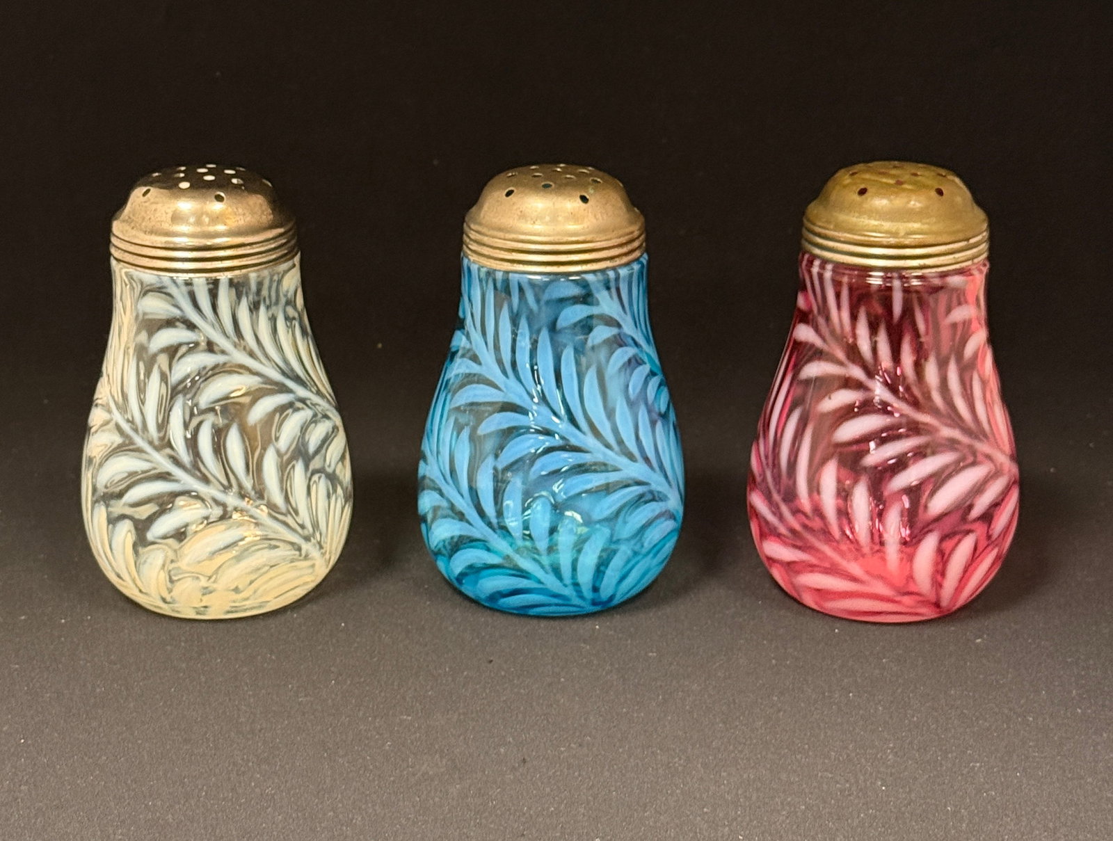 3 Opalescent Fern Sugar Shakers: 3 opalescent fern sugar shakers in blue, cranberry, clear; ht. 5 1/4". CONDITION: no chips, cracks, repairs, or material defects found, Jaremos attempts to call any material flaw that affects the