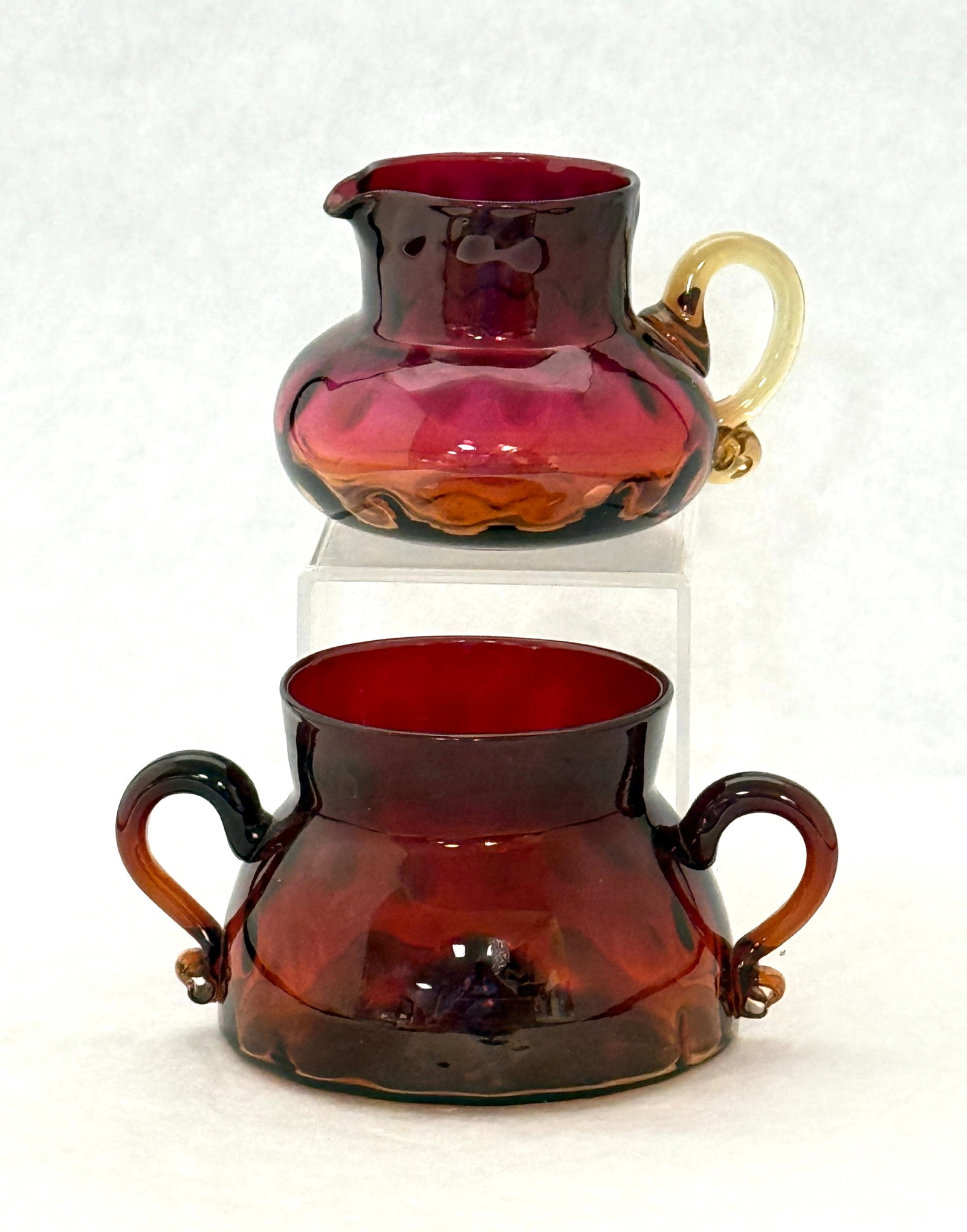Amberina Sugar and Cream: Mt. Washington Amberina sugar and cream pitcher in dark Rose Amber color, sugar 5 1/4" wide. CONDITION: no chips, cracks, repairs, or material defects found, Jaremos attempts to call any material