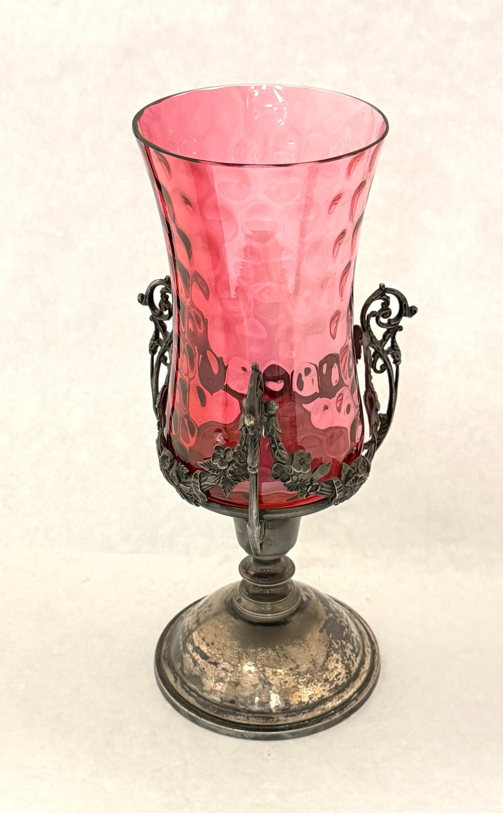 Cranberry Celery Vase and Stand: Cranberry coin spot celery vase set in a marked Pairpoint stand, 11 1/2' ht. CONDITION: Glass is good with one embedded ash, stand with tarnish.