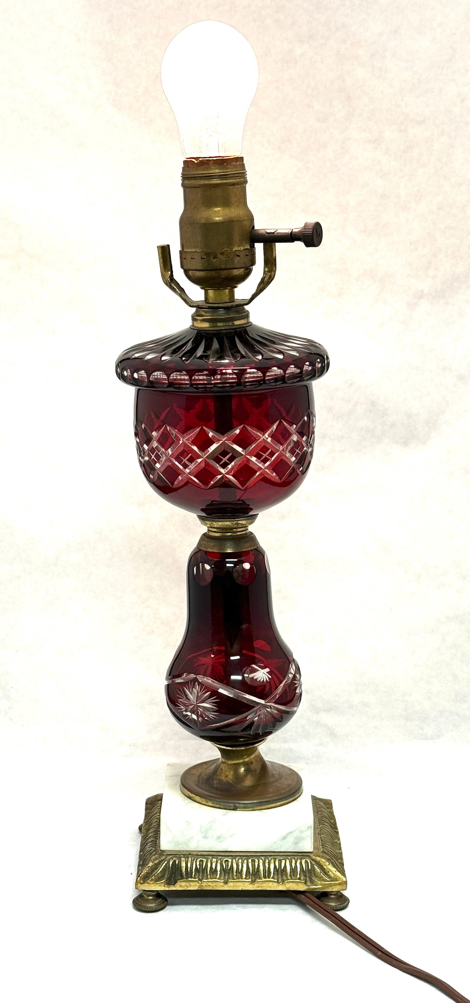 Ruby Cut to Clear Lamp: Ruby cut to clear lamp on marble base; ht. 15" without bulb and shade. CONDITION: no chips, cracks, repairs, or material defects found, Jaremos attempts to call any material flaw that affects the pric