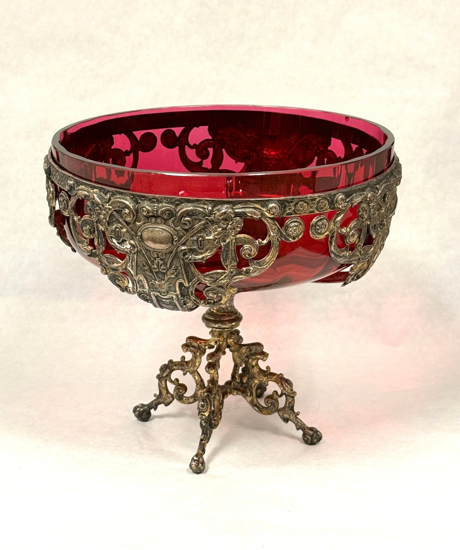 Cranberry Bowl in Metal Stand: Continental cranberry glass bowl in a reticulated metal footed stand; ht. 7 1/2". CONDITION: small flake on rim, see picture.