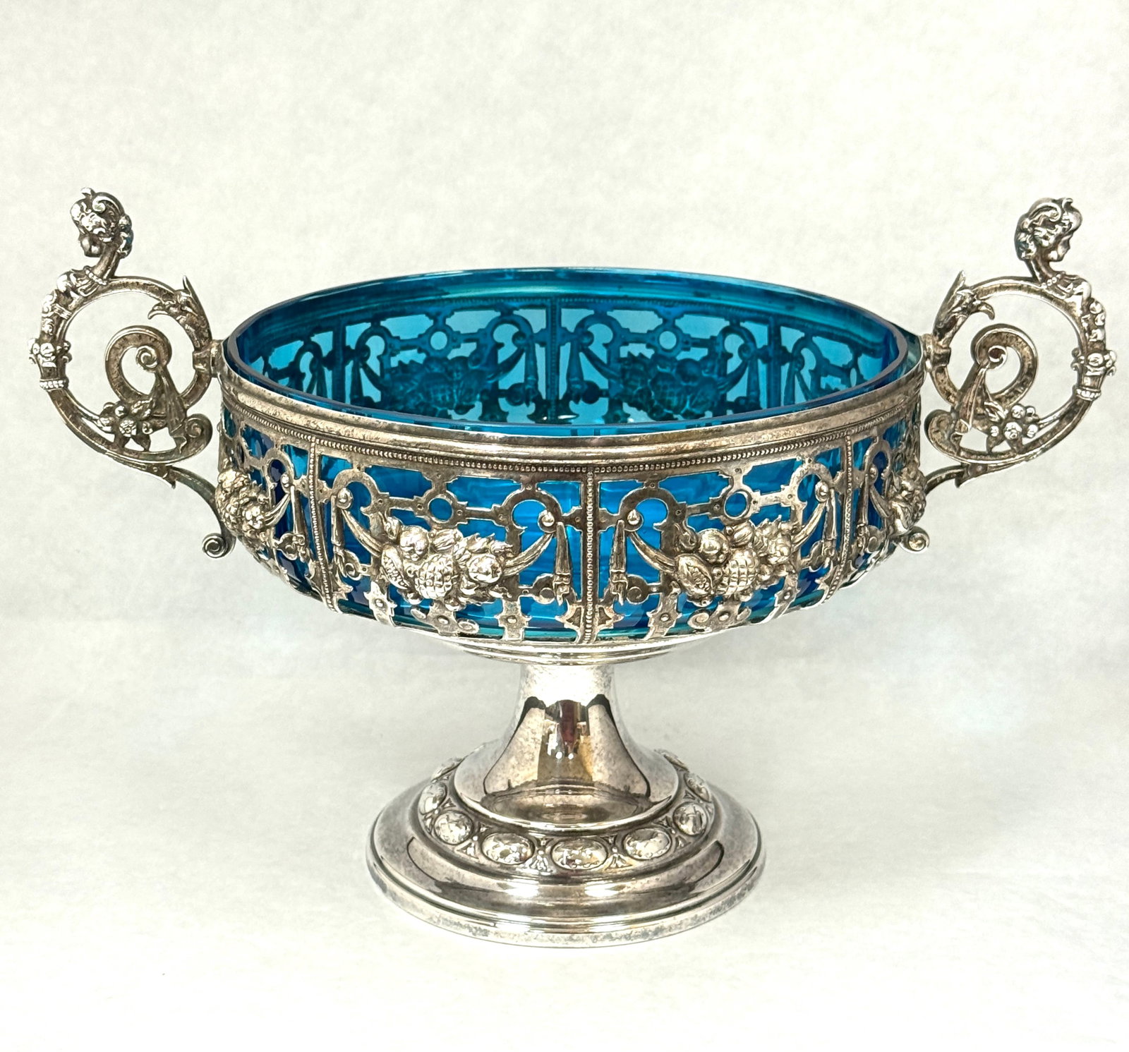 Blue Bowl in Metal Stand: Continental blue glass bowl set in a reticulated stand with handles; ht. 8 1/2". CONDITION: no chips, cracks, repairs, or material defects found, Jaremos attempts to call any material flaw that