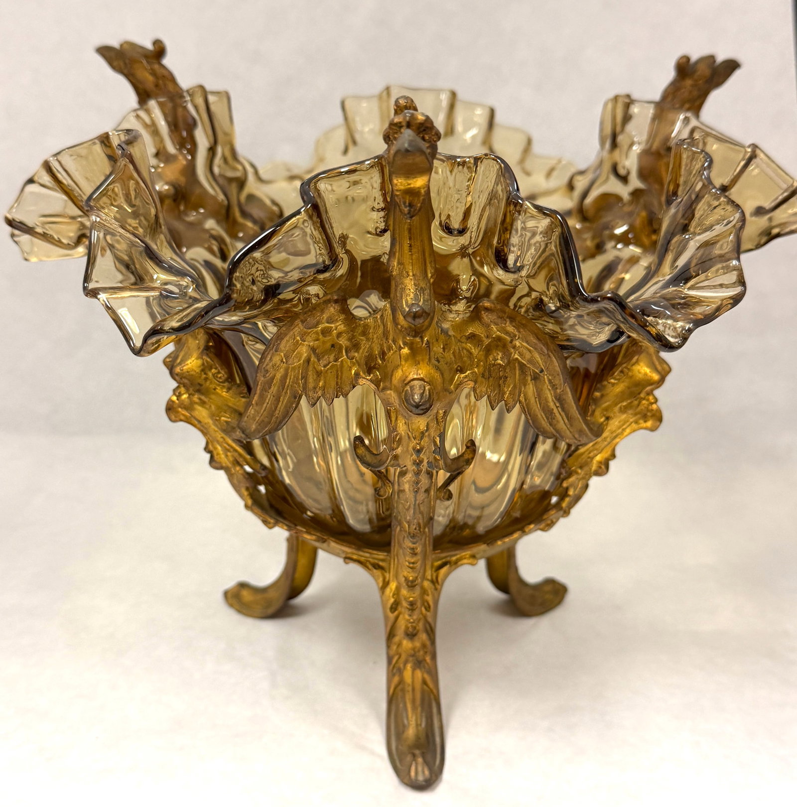 Amber Bowl in Metal Stand: Continental amber ruffle rimmed bowl in metal frame with griffins; ht. 9 1/4". CONDITION: no chips, cracks, repairs, or material defects found, Jaremos attempts to call any material flaw that affects 