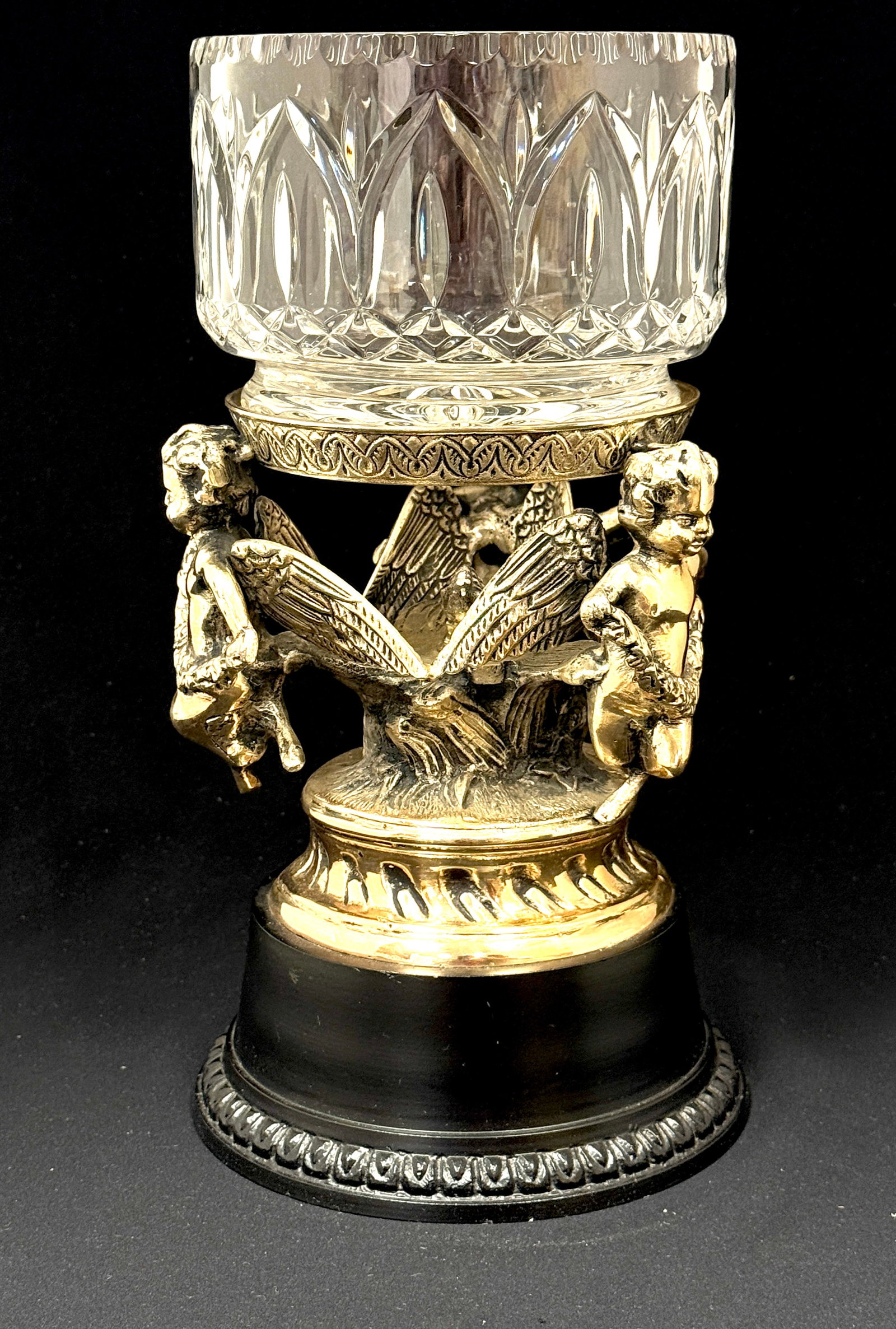 Cut Glass Bowl in Metal Stand: Cut glass bowl in metal stand with cherubs; ht. 12". CONDITION: no chips, cracks, repairs, or material defects found, Jaremos attempts to call any material flaw that affects the price, but minor