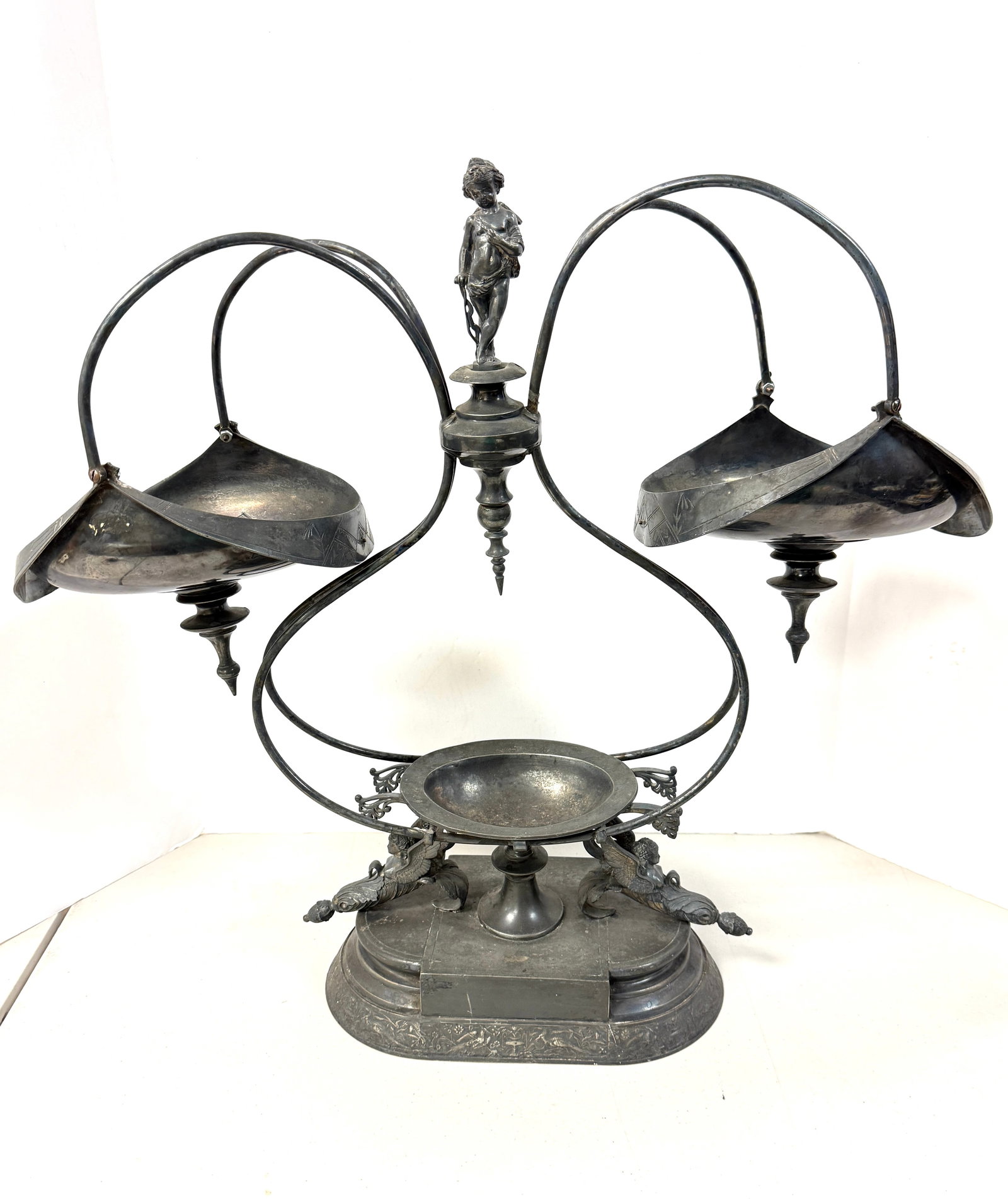 Metal Epergne with Baskets: Metal epergne with 2 hanging baskets and cherubs; ht. 23". CONDITION: no chips, cracks, repairs, or material defects found, Jaremos attempts to call any material flaw that affects the price, but minor