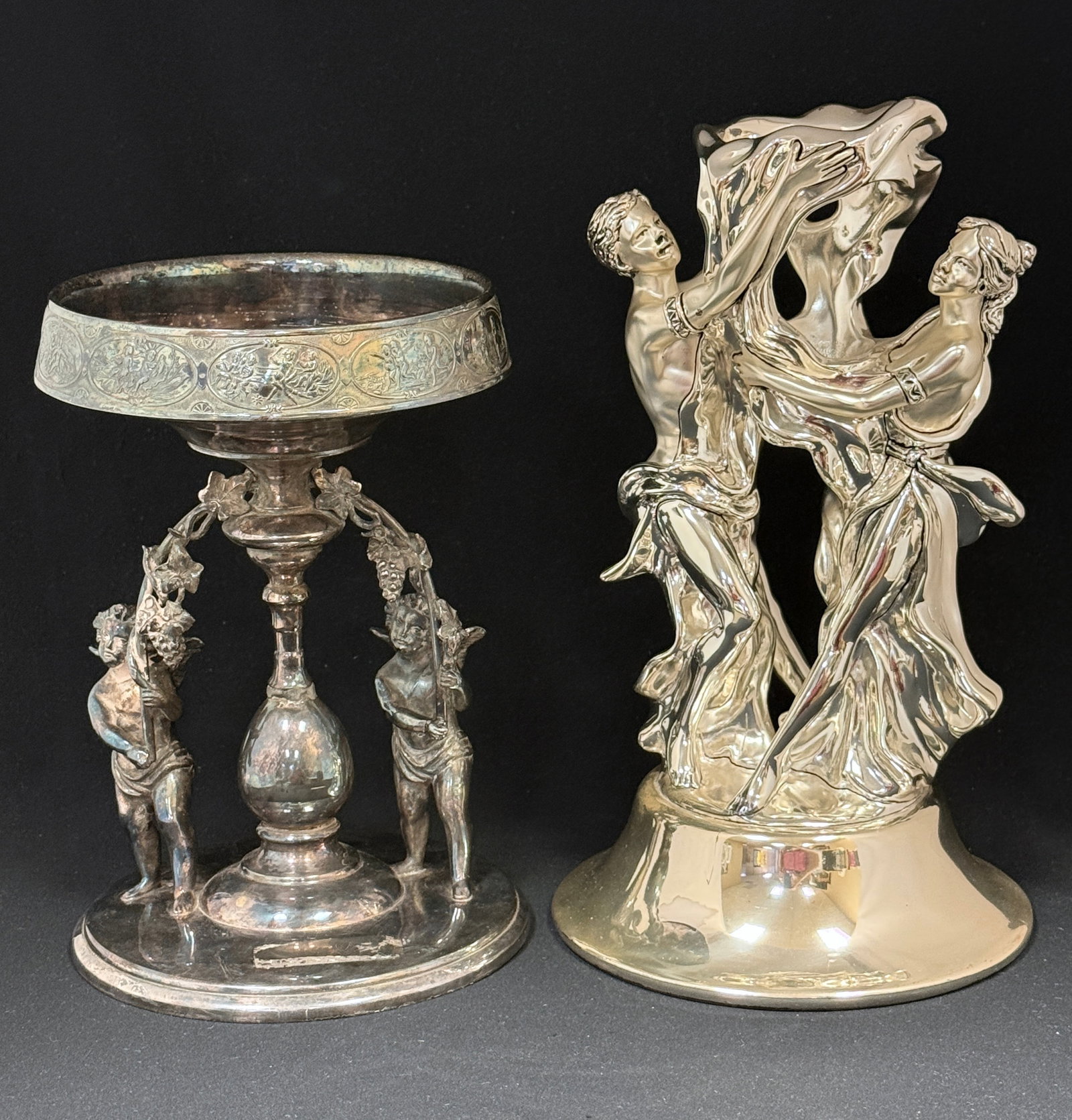 2 Metal Stands: 2 metal stands, a Middleton with cherubs the other with Grecian figures by Marcello Georgio; ht. tallest 12". CONDITION: no chips, cracks, repairs, or material defects found, Jaremos attempts to call