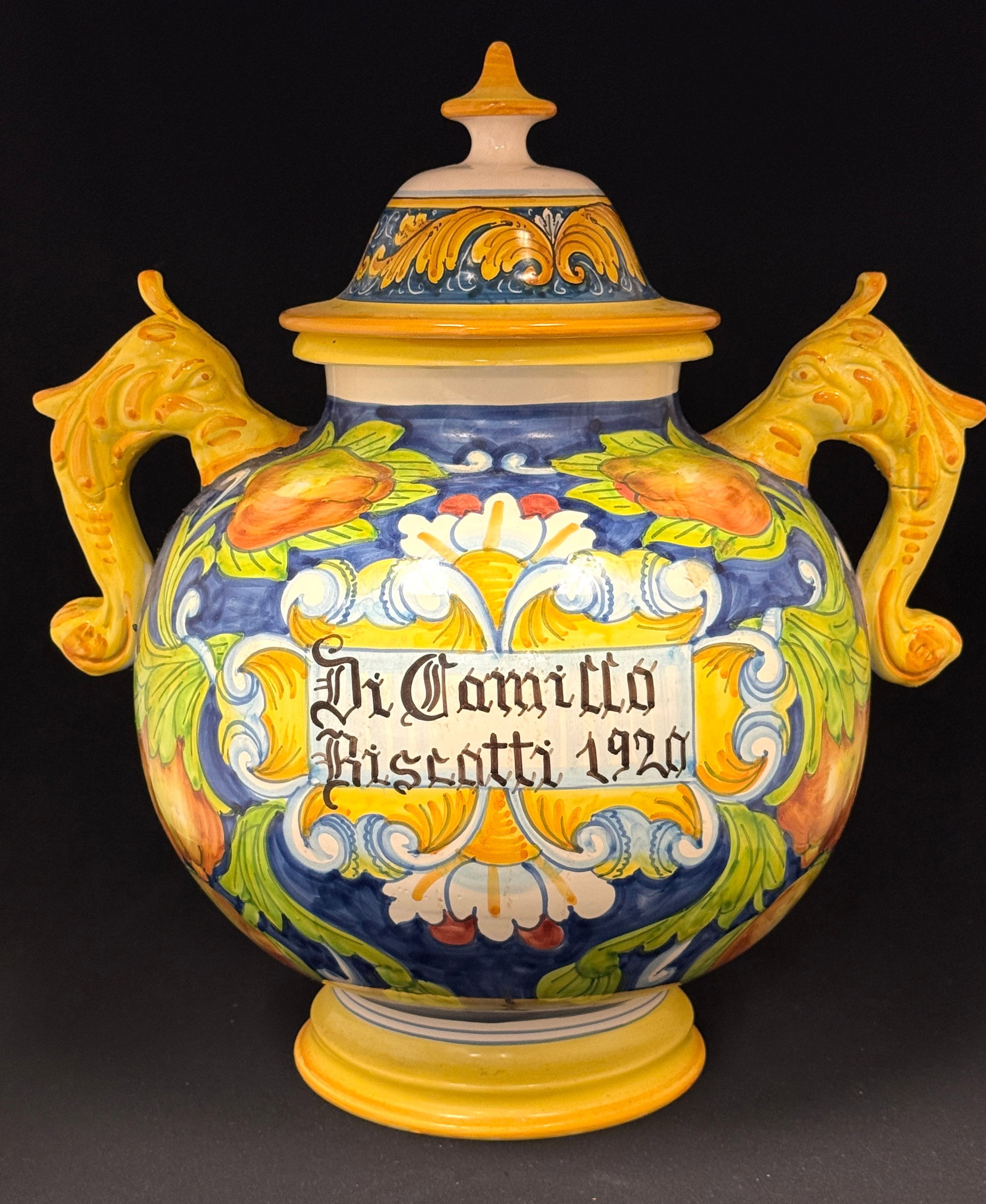 Large Deruta Covered Biscotti Jar: Large colorful covered Deruta Biscotti jar with griffin handles, " Di Camillo Biscotti 1920", signed made in Italy; ht. 13 1/2". CONDITION: no chips, cracks, repairs, or material defects found, Jaremo