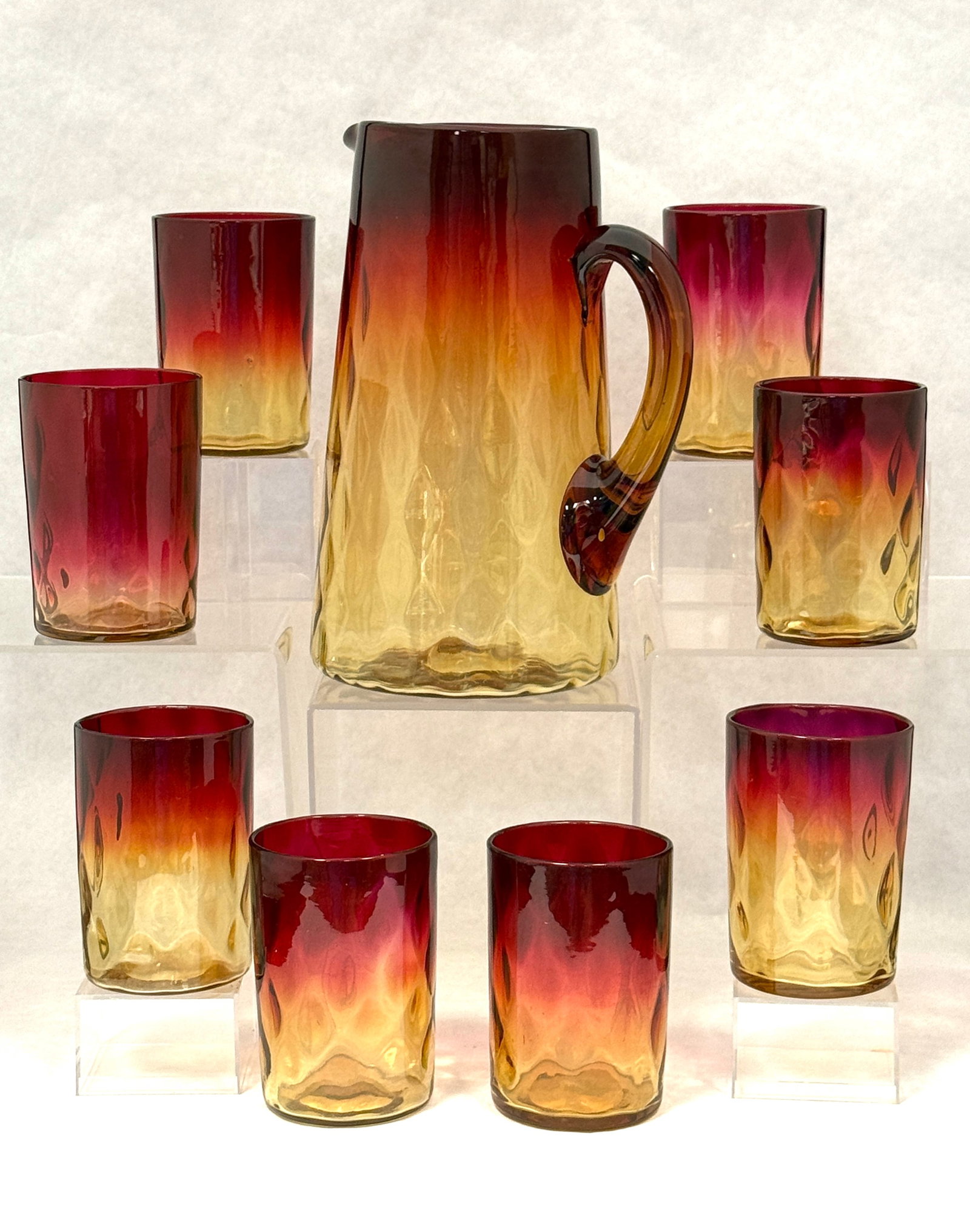 Amberina Pitcher and Tumblers: Amberina Optic Diamond Water Pitcher with eight tumblers, 7" ht. CONDITION: no chips, cracks, repairs, or material defects found, Jaremos attempts to call any material flaw that affects the price,
