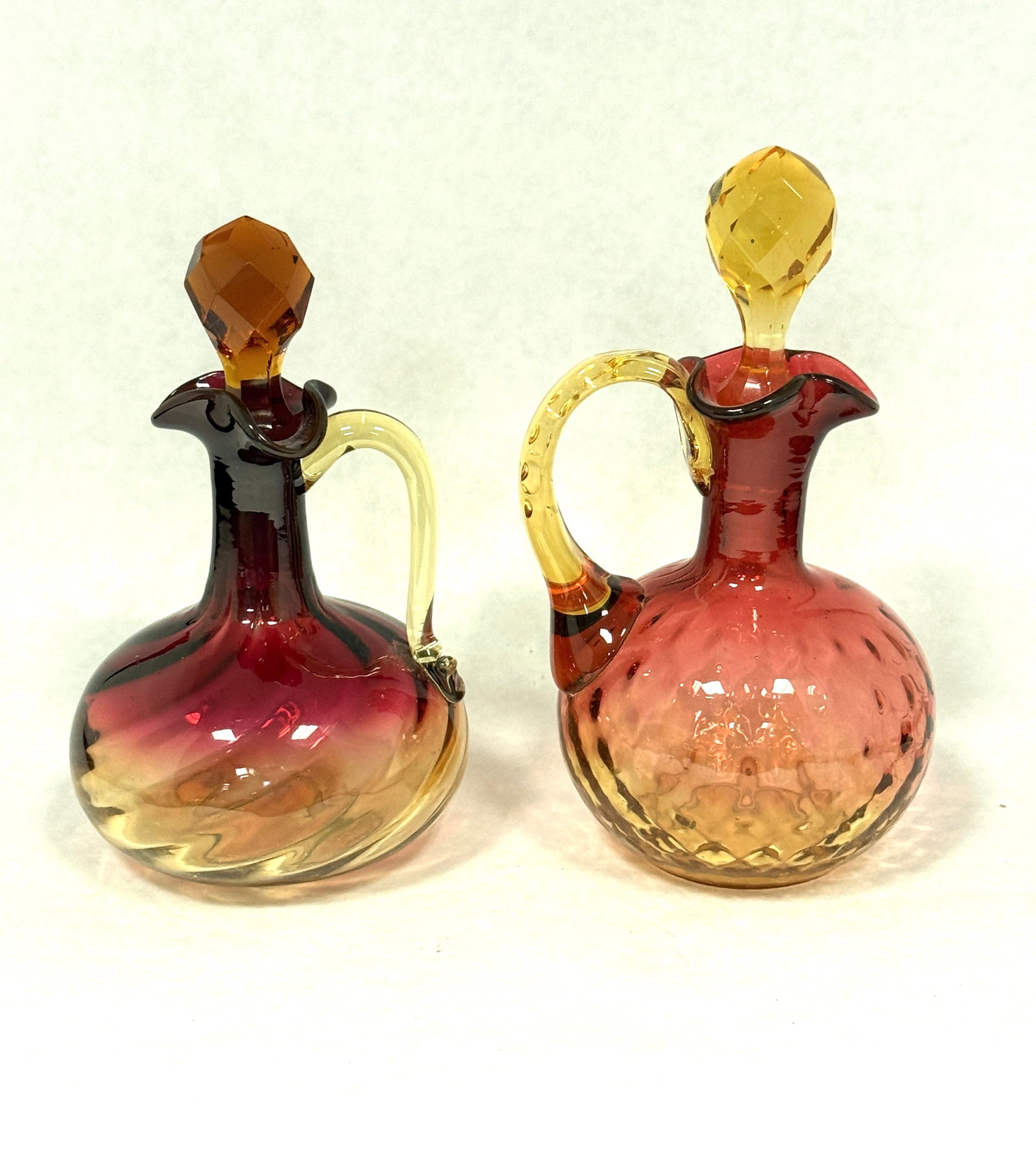2 Amberina Cruets: 2 Amberina cruets one swirl and one honey comb; ht. 6 1/2". CONDITION: no chips, cracks, repairs, or material defects found, Jaremos attempts to call any material flaw that affects the price, but