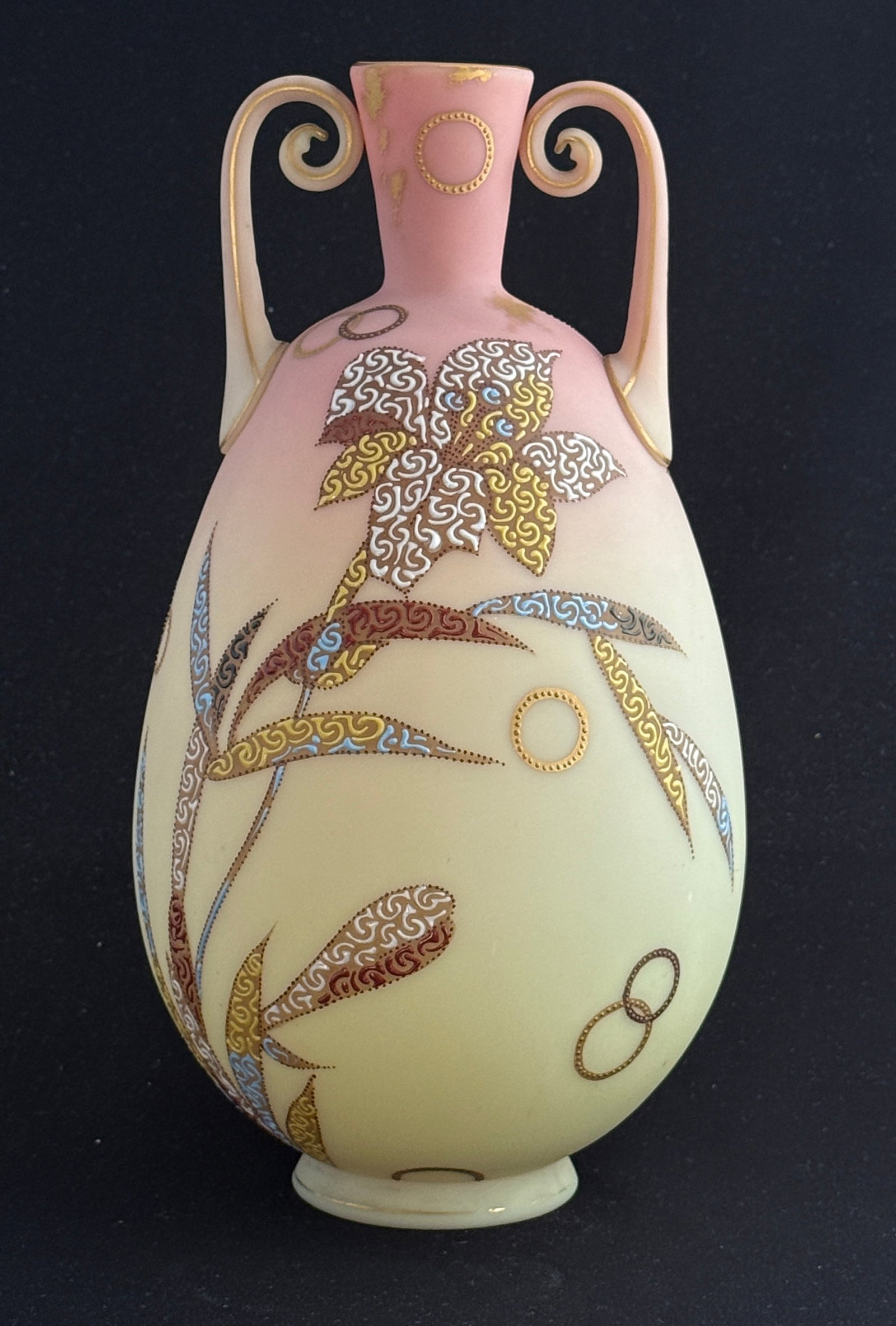 2 Handled Burmese Vase: Mt. Washington 2 handled Burmese vase bulbous form decorated with colorful stemmed flowers and stippled circles, 10 1/4" ht. CONDITION: no chips, cracks, repairs, or material defects found, Jaremos