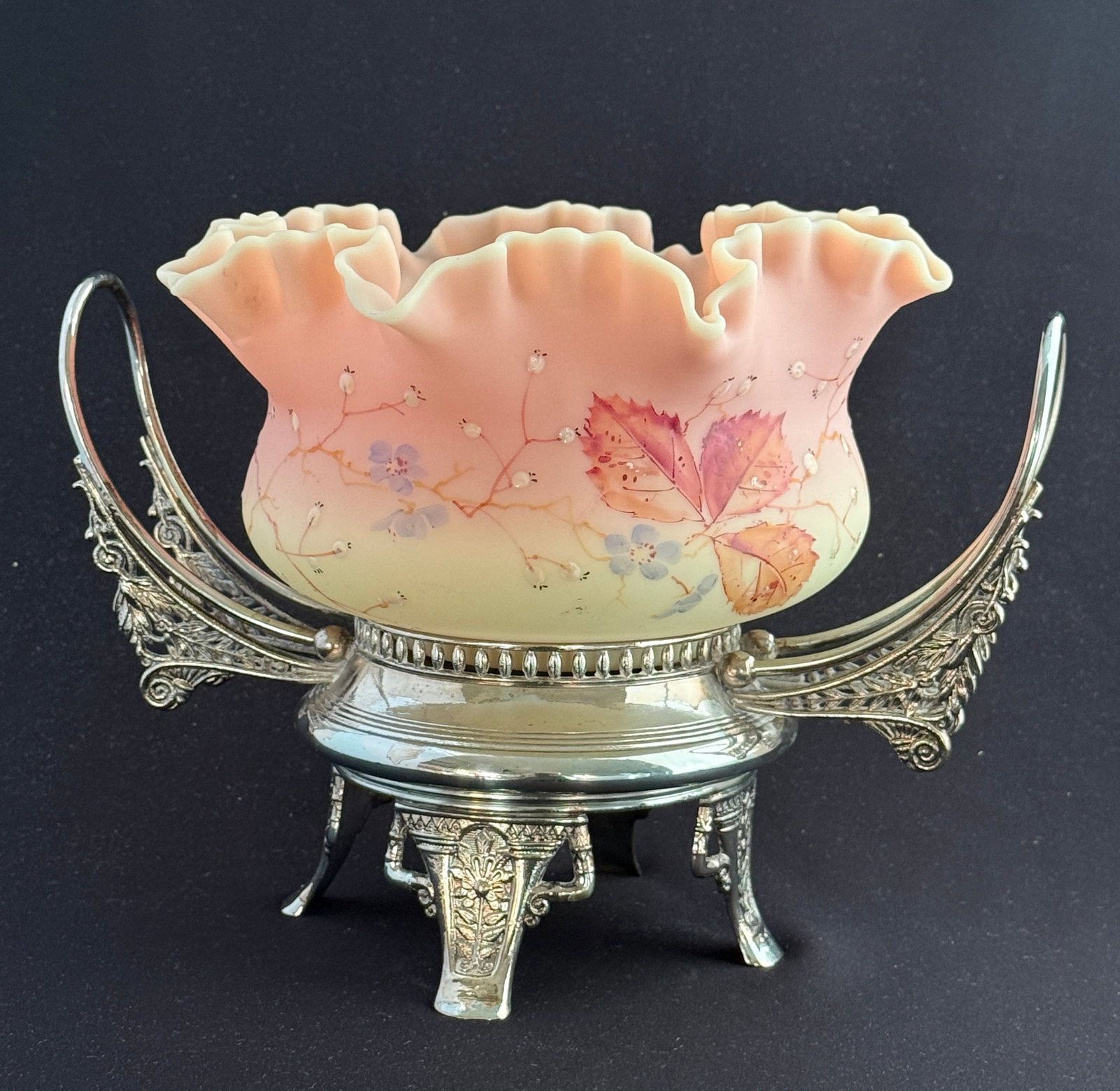 Burmese Bride's Basket: Mt. Washington ruffled rim Burmese bride's bowl with oak leaves and white seed pots set in a two handled silver plate caddy, 11" wide. PROVENANCE: Earlys Auction Co CONDITION: no chips, cracks,