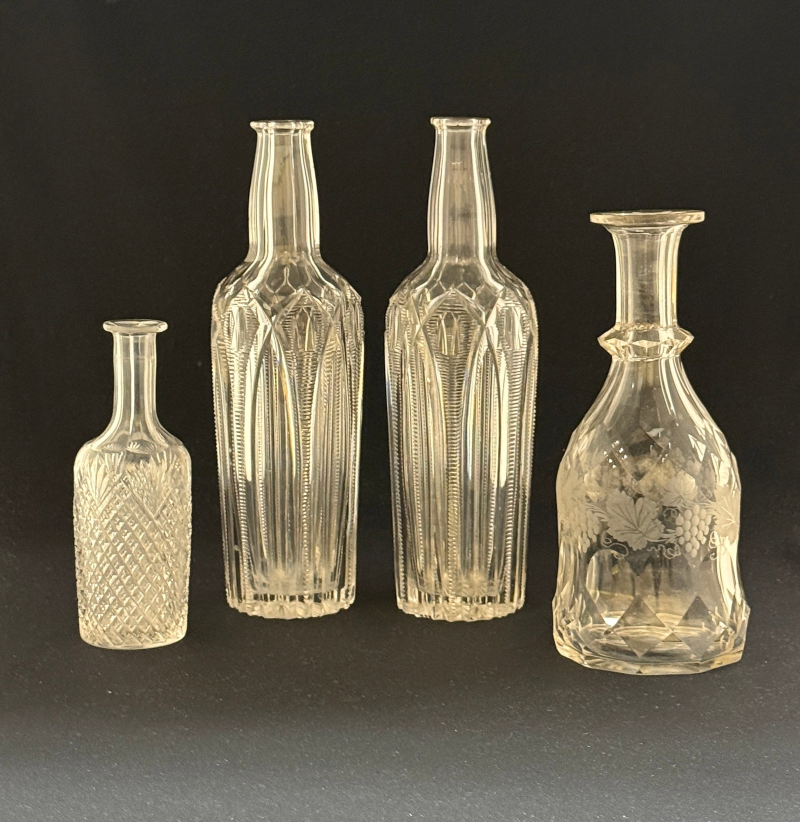 4 Cut Glass bottles: 4 Cut Glass bottles, various makers, 11" ht. CONDITION: no chips, cracks, repairs, or material defects found, Jaremos attempts to call any material flaw that affects the price, but minor scratches