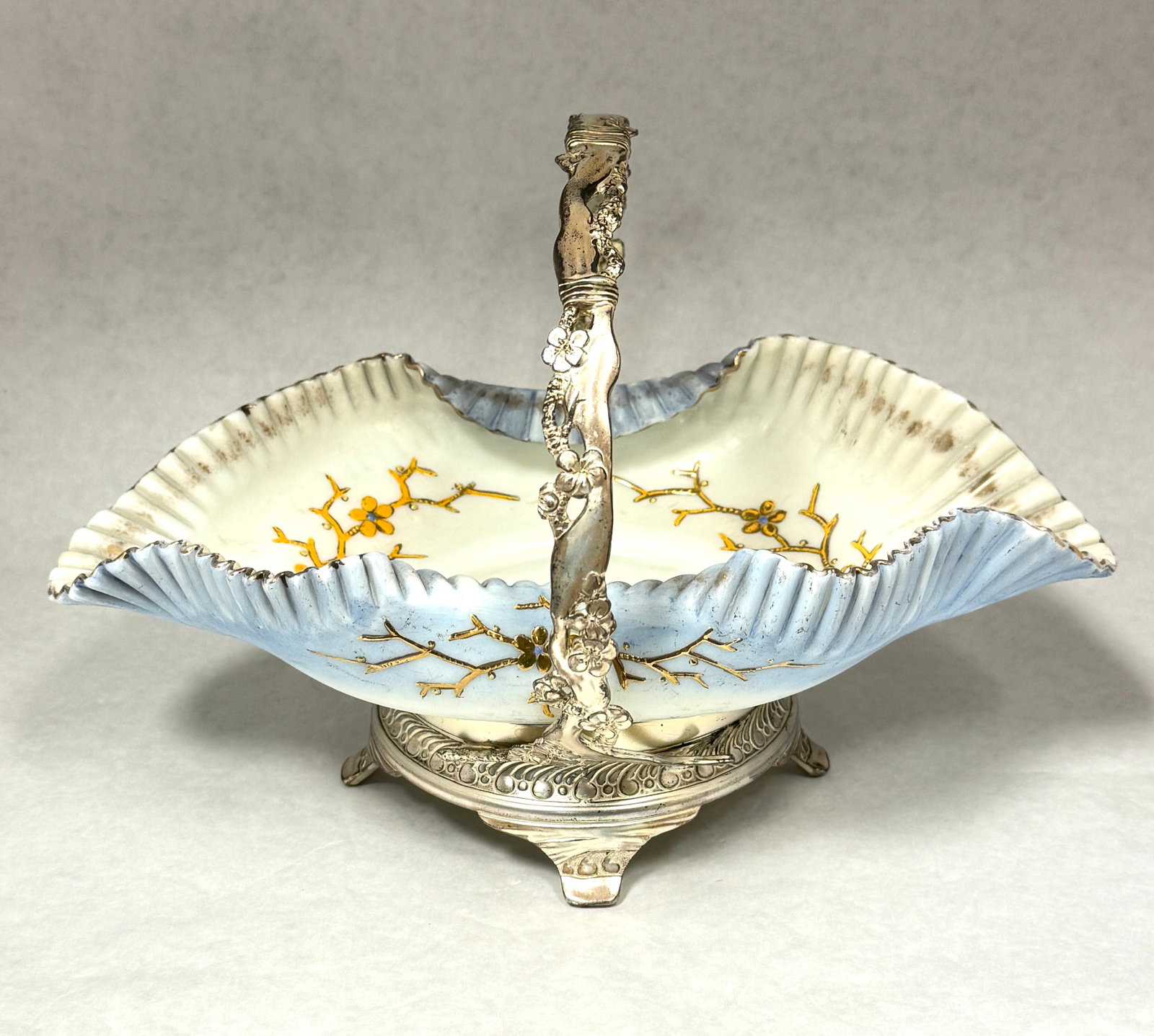 Mt. Washington Bride's Basket: Mt. Washington bride's basket with gold enameling set in a Pairpoint metal holder; length 11". CONDITION: no chips, cracks, repairs, or material defects found, Jaremos attempts to call any material fl