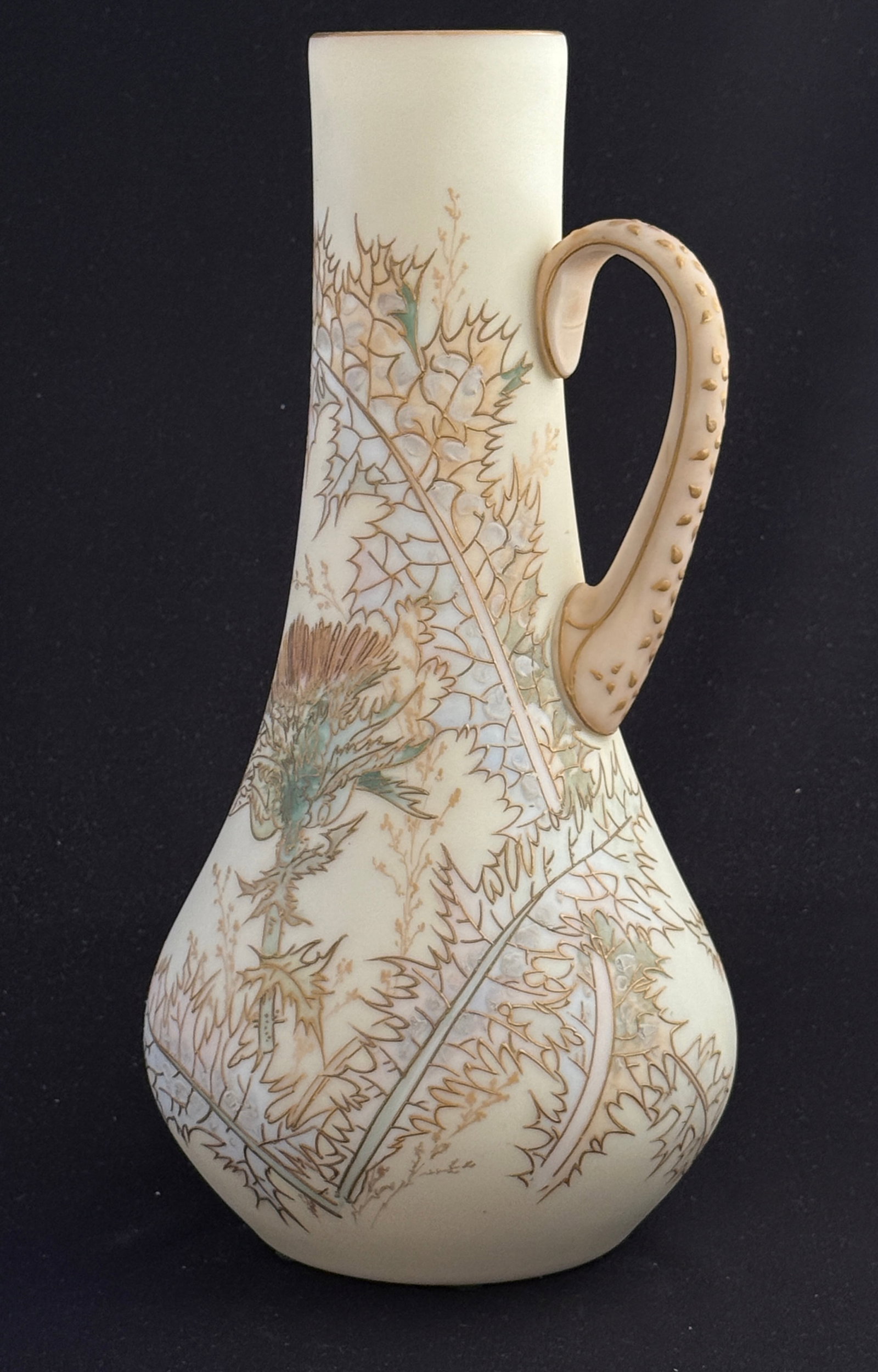 Mt. Washington Glass Ewer: Mt. Washington Crown Milano opal glass ewer decorated with a long stem thistle, partial paper label, 12" ht. CONDITION: no chips, cracks, repairs, or material defects found, Jaremos attempts to call a
