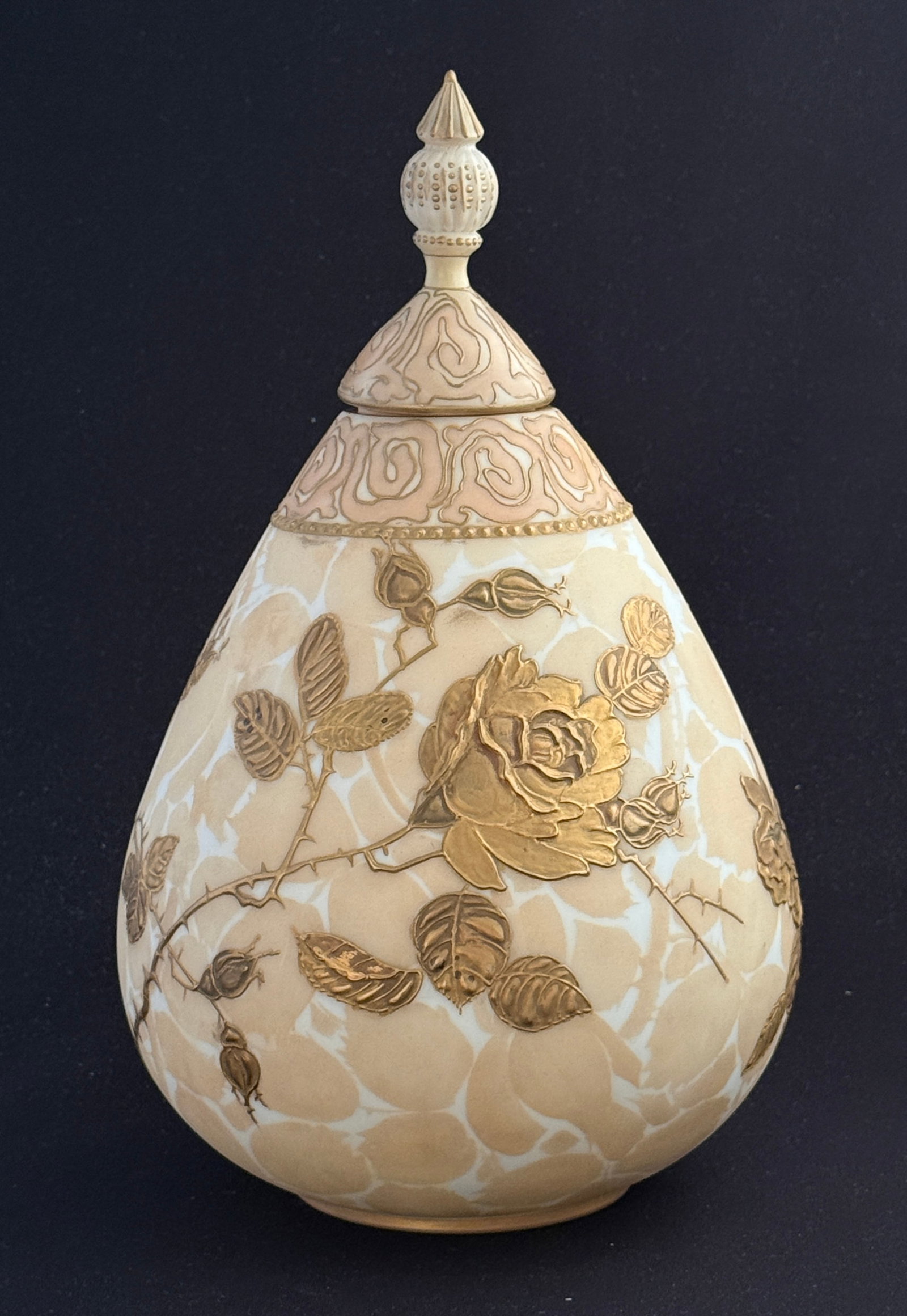 Mt. Washington Covered Urn: Mt. Washington Crown Milano covered urn, ovoid form in opal glass decorated with raised gold Primrose on thorny leafy vines, matching crown finial, 12" ht. CONDITION: professional repair to the finial