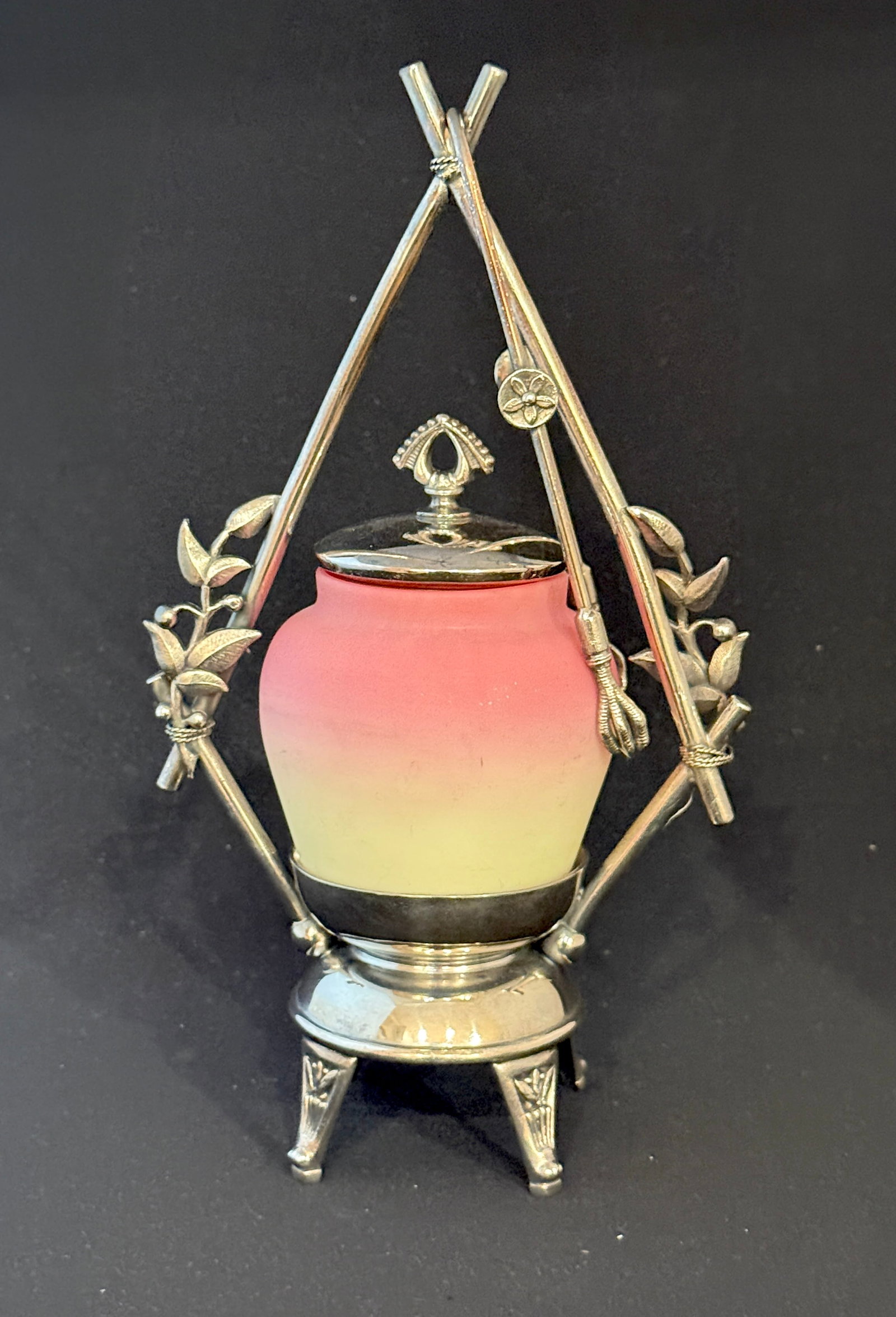 Burmese glass pickle castor: Burmese glass pickle castor set in a triangular leaf embossed Meriden caddy, 10 1/2" ht. CONDITION: no chips, cracks, repairs, or material defects found, Jaremos attempts to call any material flaw tha