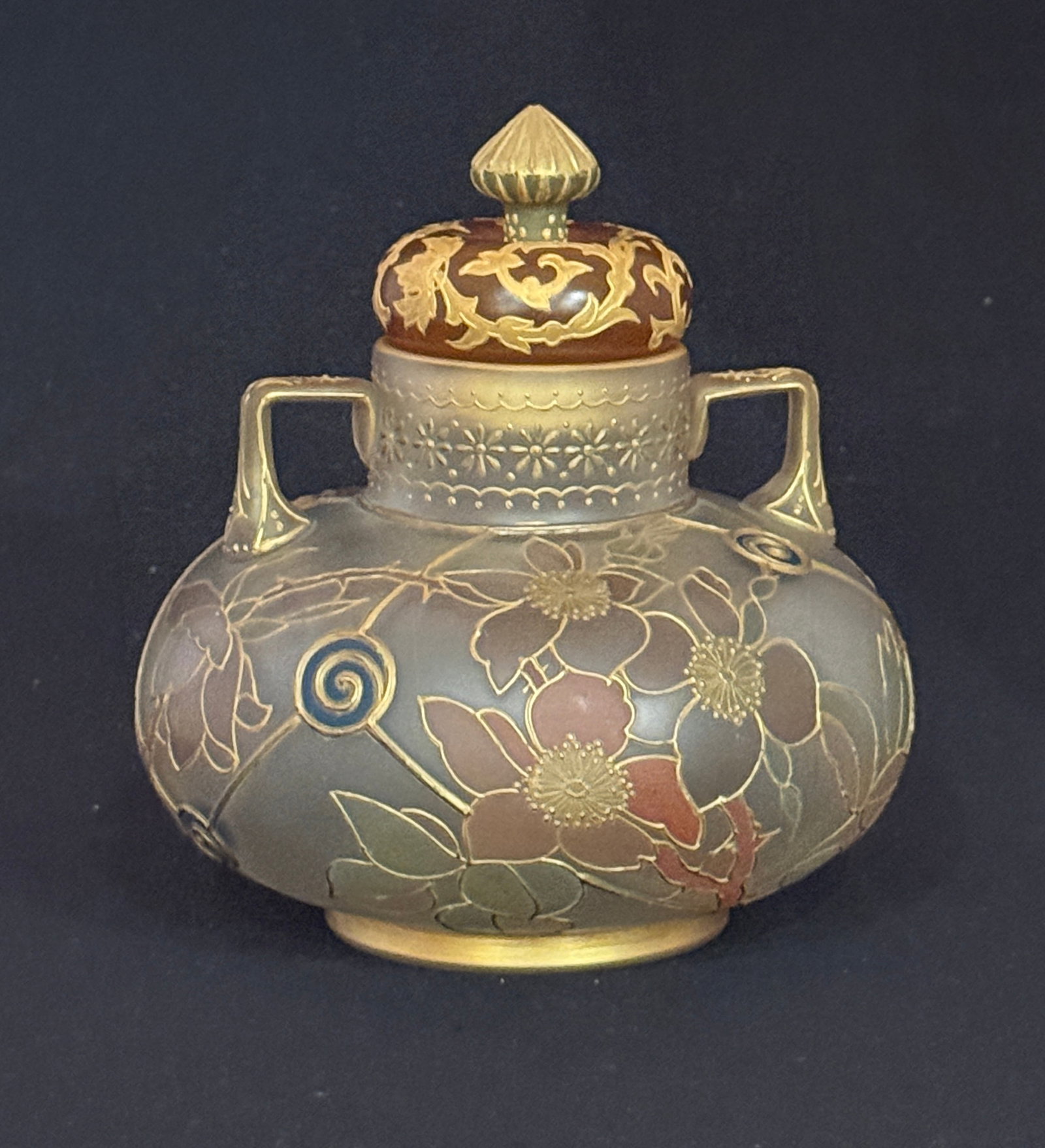 Mt. Washington Vase: Mt Washington two handled Royal Flemish vase in blue panels decorated with pink flowers and with a associated crown finial lid, 6 1/2" ht. CONDITION: no chips, cracks, repairs, or material defects