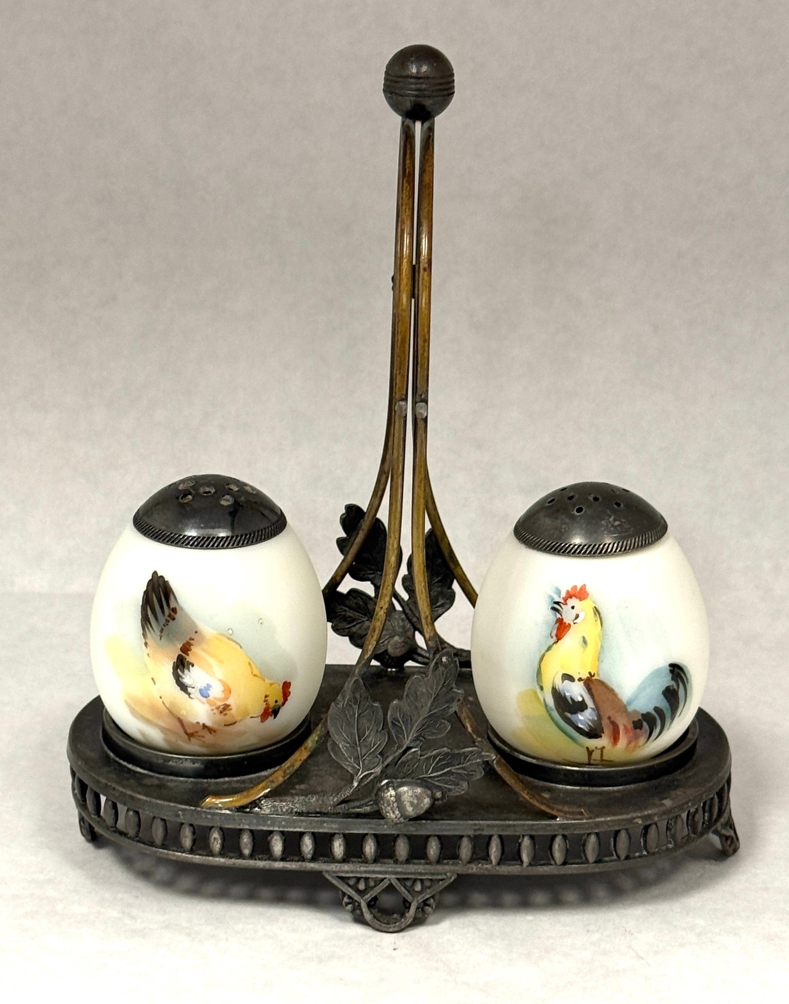 Mt. Washington Rooster Shakers: Mt. Washington rooster salt and pepper shakers in metal holder; shakers ht. 2 1/2", holder ht. 7 1/2". CONDITION: no chips, cracks, repairs, or material defects found, Jaremos attempts to call any