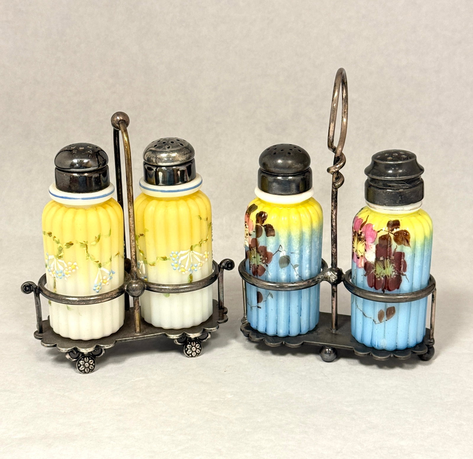 Mt. Washington Ribbed Pillar Salts: 2 sets of Mt. Washington ribbed pillar salt shakers in holders, one set blue and yellow with enameled flowers and one set yellow and white with enameled flowers; tallest ht. 6". CONDITION: no chips,