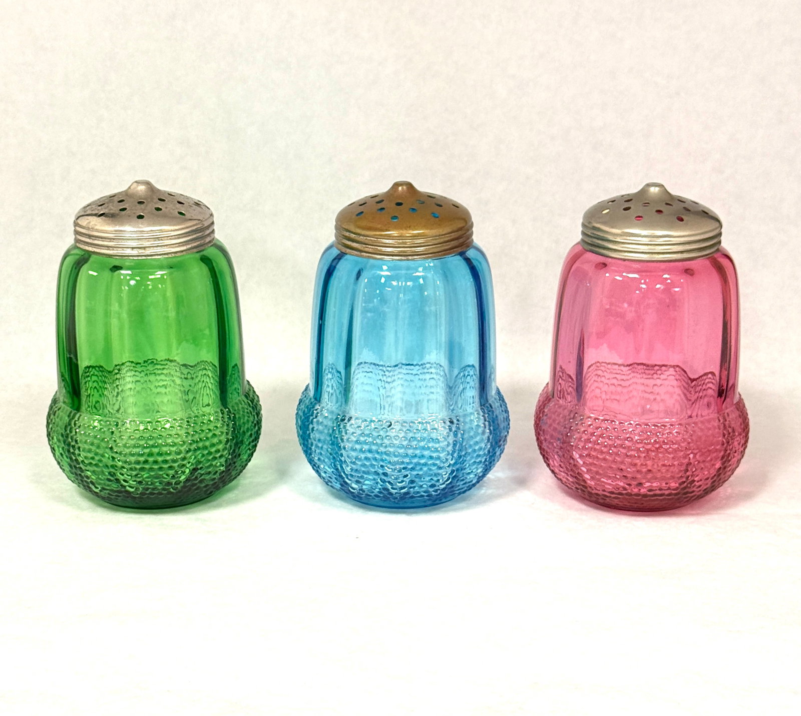3 Beaumont Acorn Sugar Shakers: 3 Beaumont acorn sugar shakers a rare cranberry, a green, and a blue; ht. 5". CONDITION: no chips, cracks, repairs, or material defects found, Jaremos attempts to call any material flaw that affects