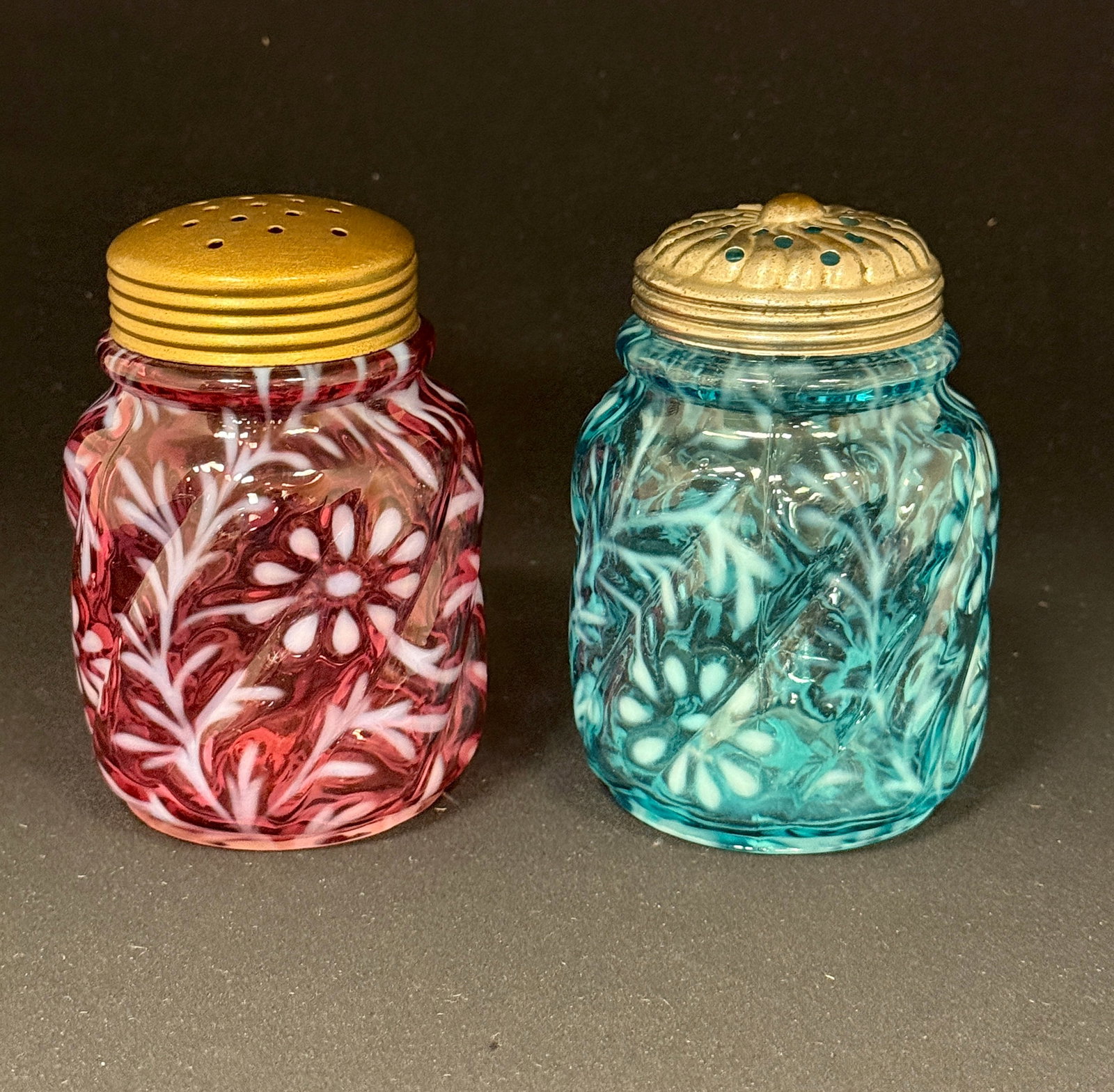 2 Northwood Opalescent Shakers: 2 Northwood opalescent daisy and fern swirl sugar shakers one cranberry and one blue; ht. 4 1/2". CONDITION: no chips, cracks, repairs, or material defects found, Jaremos attempts to call any material
