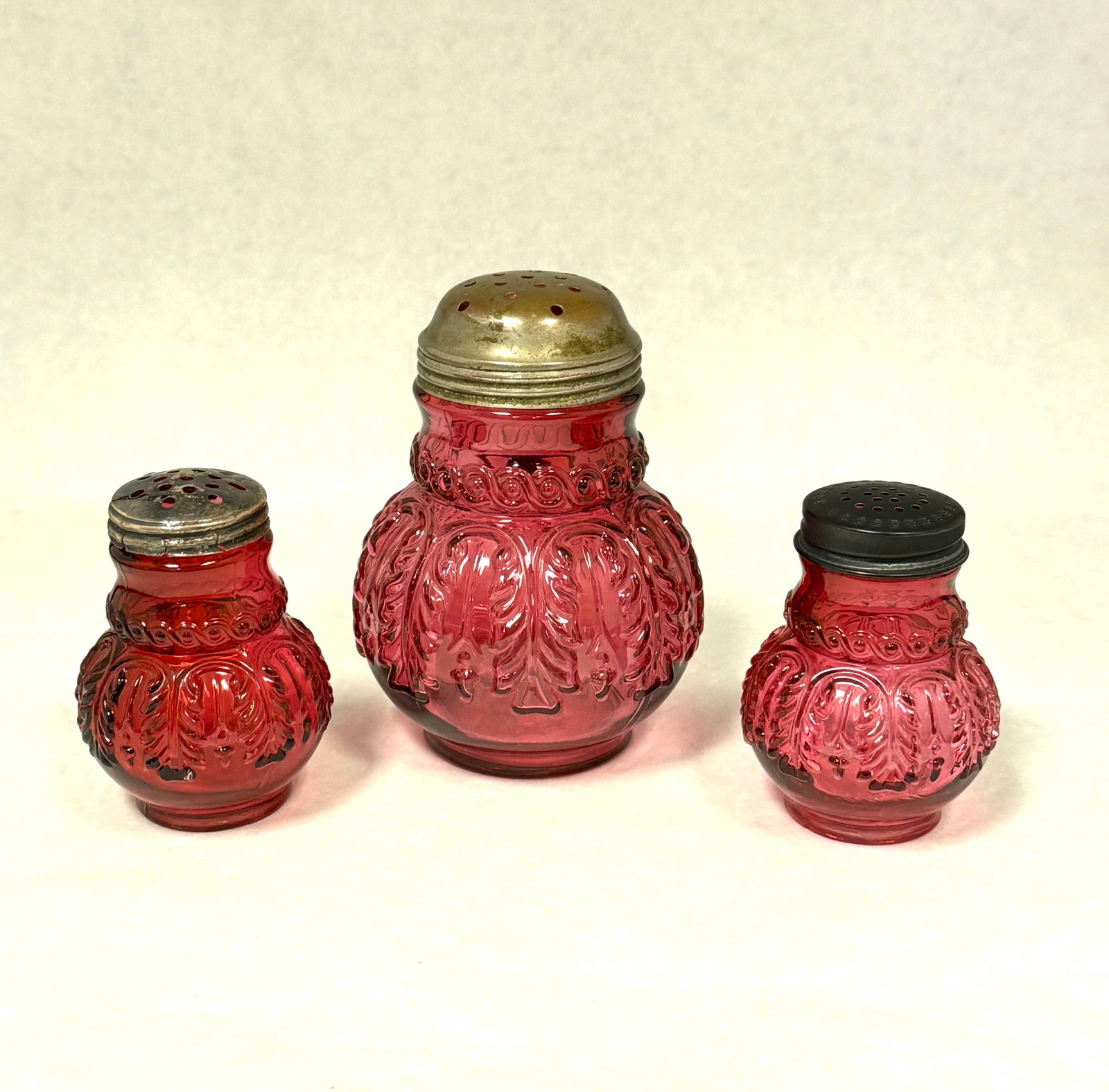 3 Cranberry Leaf Umbrella Items: 3 cranberry leaf umbrella items: small sugar shaker, salt and pepper shaker; ht. sugar 4 1/2". CONDITION: no chips, cracks, repairs, or material defects found, Jaremos attempts to call any material
