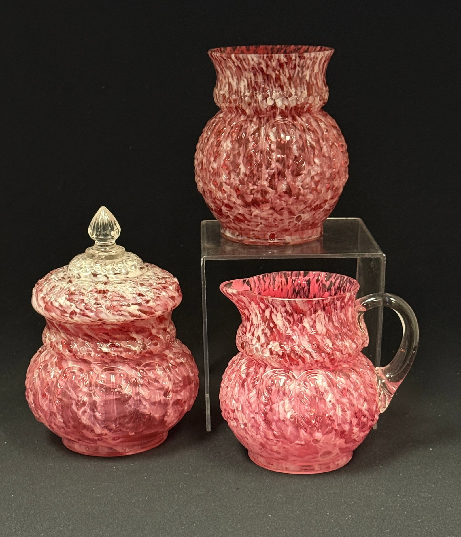 3 Opalescent Splatter Items: 3 Opalescent leaf mold cranberry splatter items: creamer, covered sugar, and celery; ht. covered sugar; ht. 6 1/4". CONDITION: no chips, cracks, repairs, or material defects found, Jaremos attempts