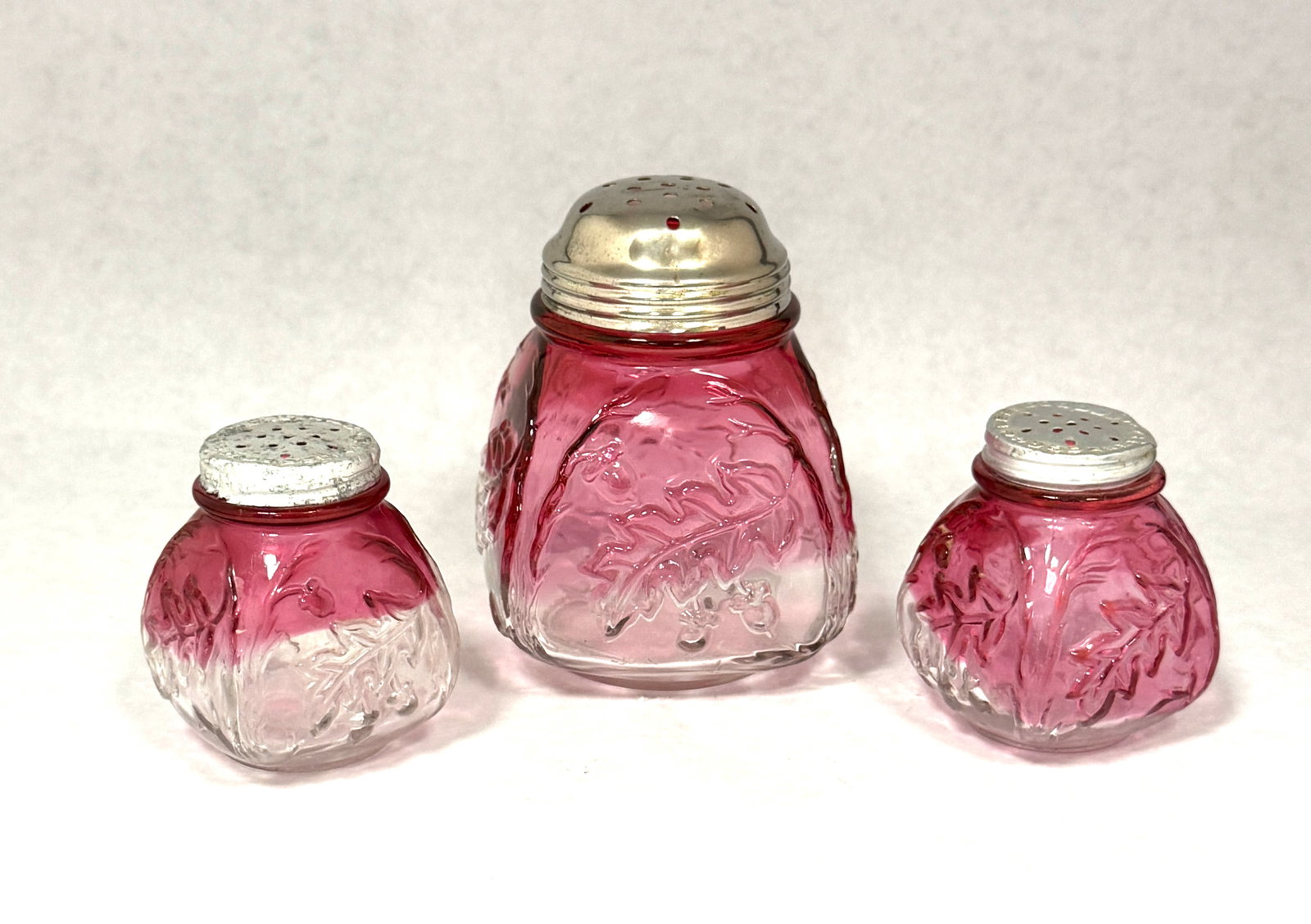 3 Northwood Royal Oak Shakers: 3 Northwood Royal Oak Rubina shakers including a sugar and two salts, 4 1/2" ht. CONDITION: no chips, cracks, repairs, or material defects found, Jaremos attempts to call any material flaw that