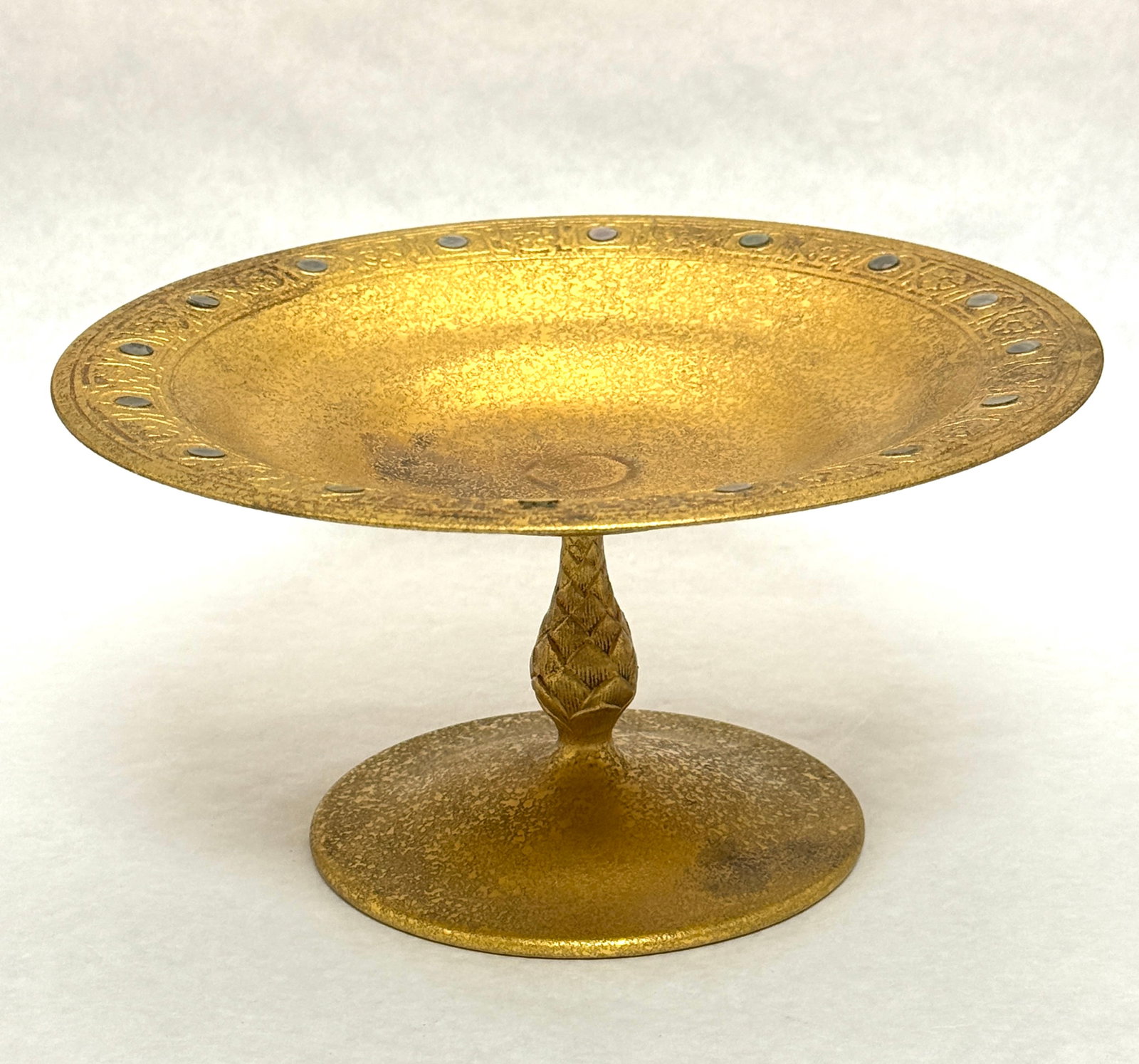 Tiffany Bronze Compote: Tiffany bronze compote with mother of pearl inlay and artichoke standard, stamped Tiffany Studios New York number 1668; ht. 4 5/8". CONDITION: no chips, cracks, repairs, or material defects found,