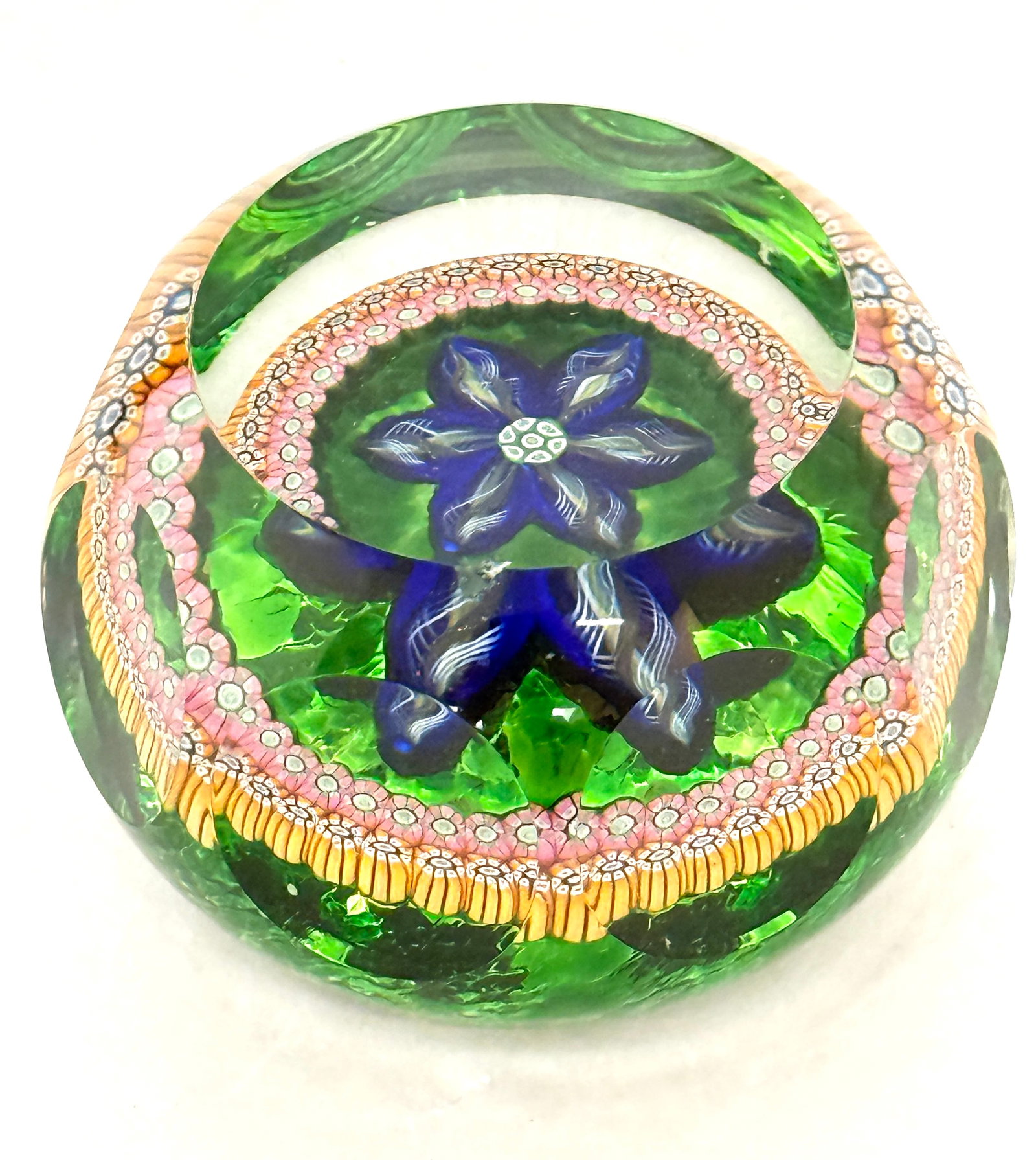 Perthshire Paperweight: Perthshire paperweight, internal blue variegated flower with millefiori border, external facets, signed P1984; diameter 3". CONDITION: no chips, cracks, repairs, or material defects found, Jaremos