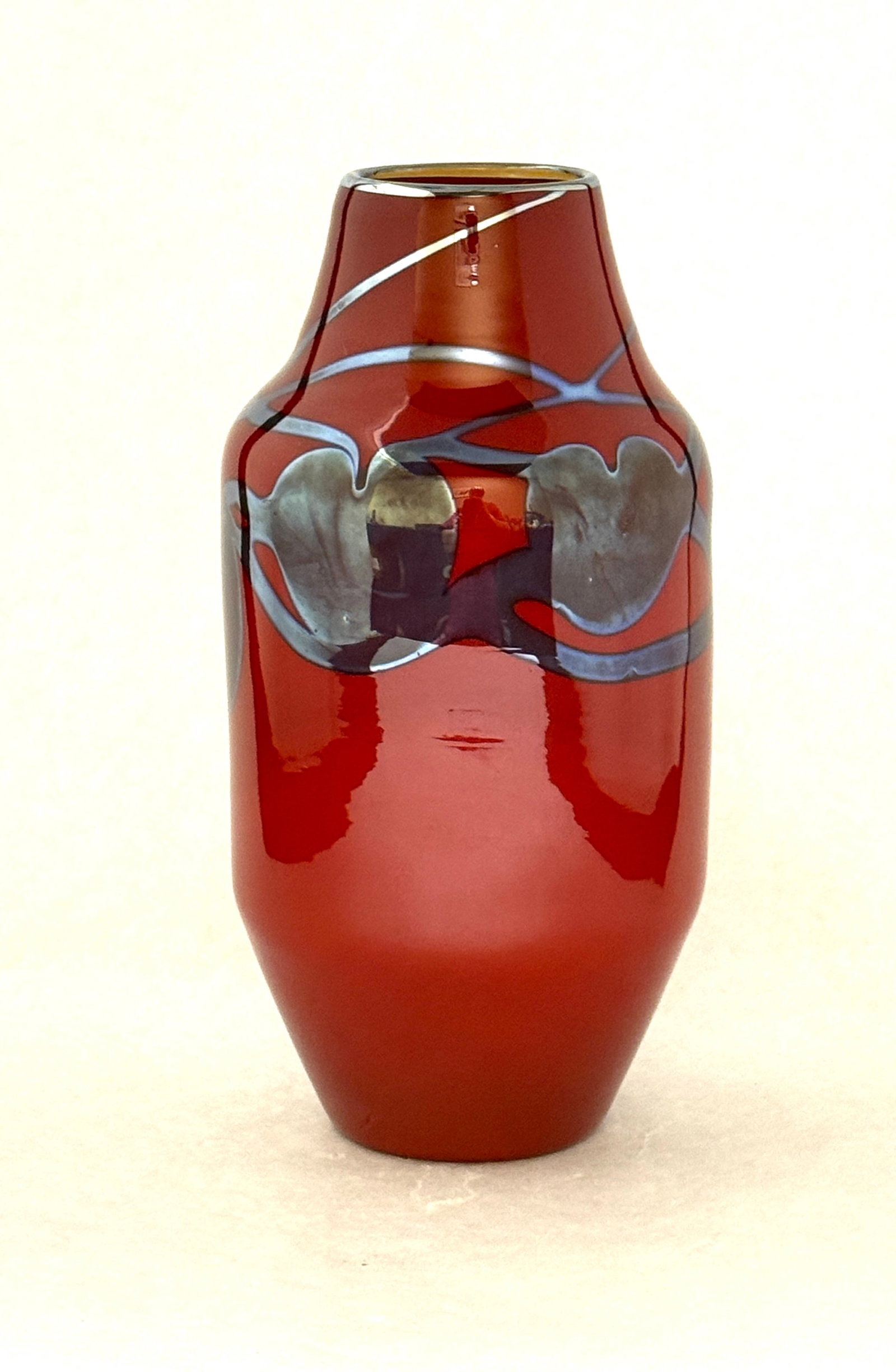 Red Lundberg Glass Vase: Cylindrical red Lundberg glass vase decorated with platinum blue heart and vines, signed Lundberg Studios 1983, 8" ht. CONDITION: no chips, cracks, repairs, or material defects found, Jaremos