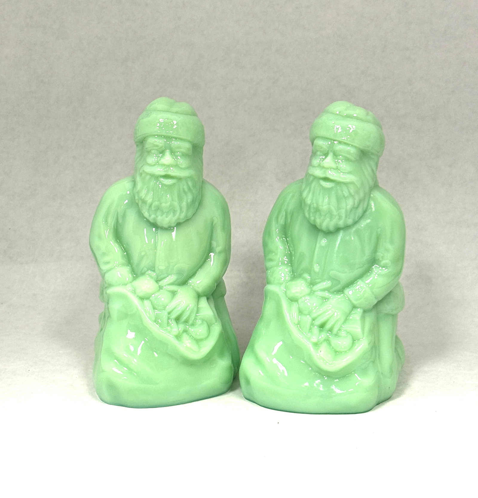 2 Jadeite Santa's: 2 Jadeite Santa's; ht. 6 1/2". CONDITION: no chips, cracks, repairs or material defects found, Jaremos attempts to call any material flaw that affects the price, but minor scratches and color