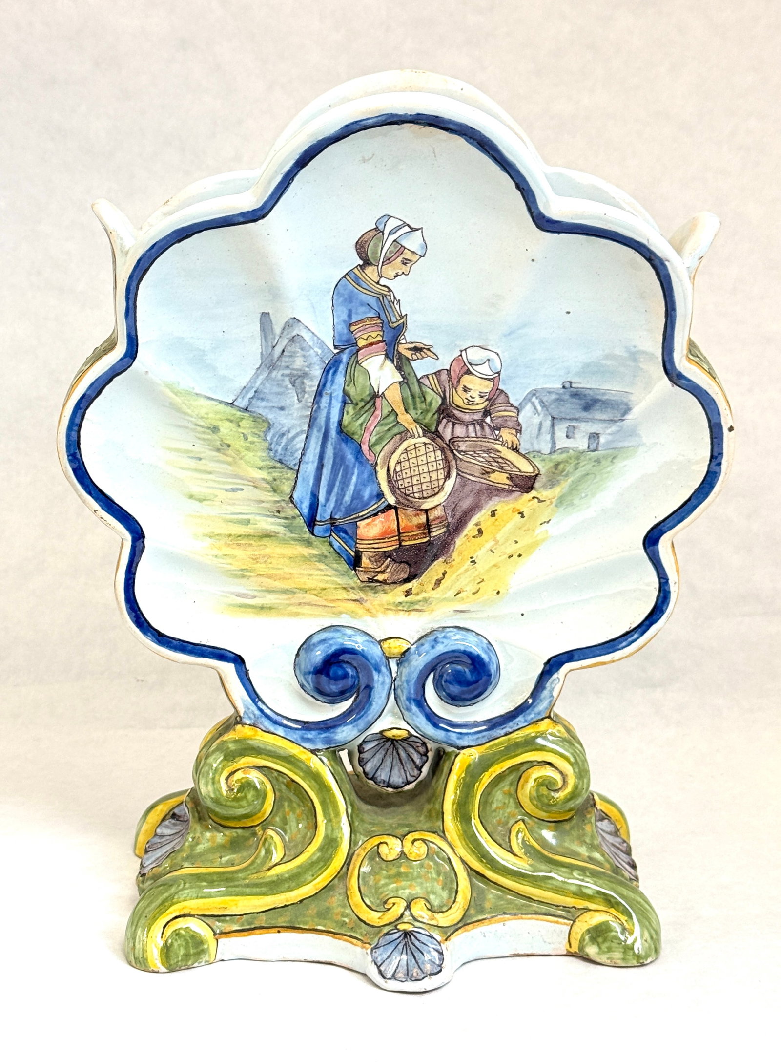Porquier Beau Jardiniere: Porquier Beau footed shell form Jardiniere circa. 1875-1898, front decorated with Bretonne and a young girl of Pont l' Abbe, reverse with Geraniums ht 10 1/2". LITERATURE: Tome II Encylopedie des Cera