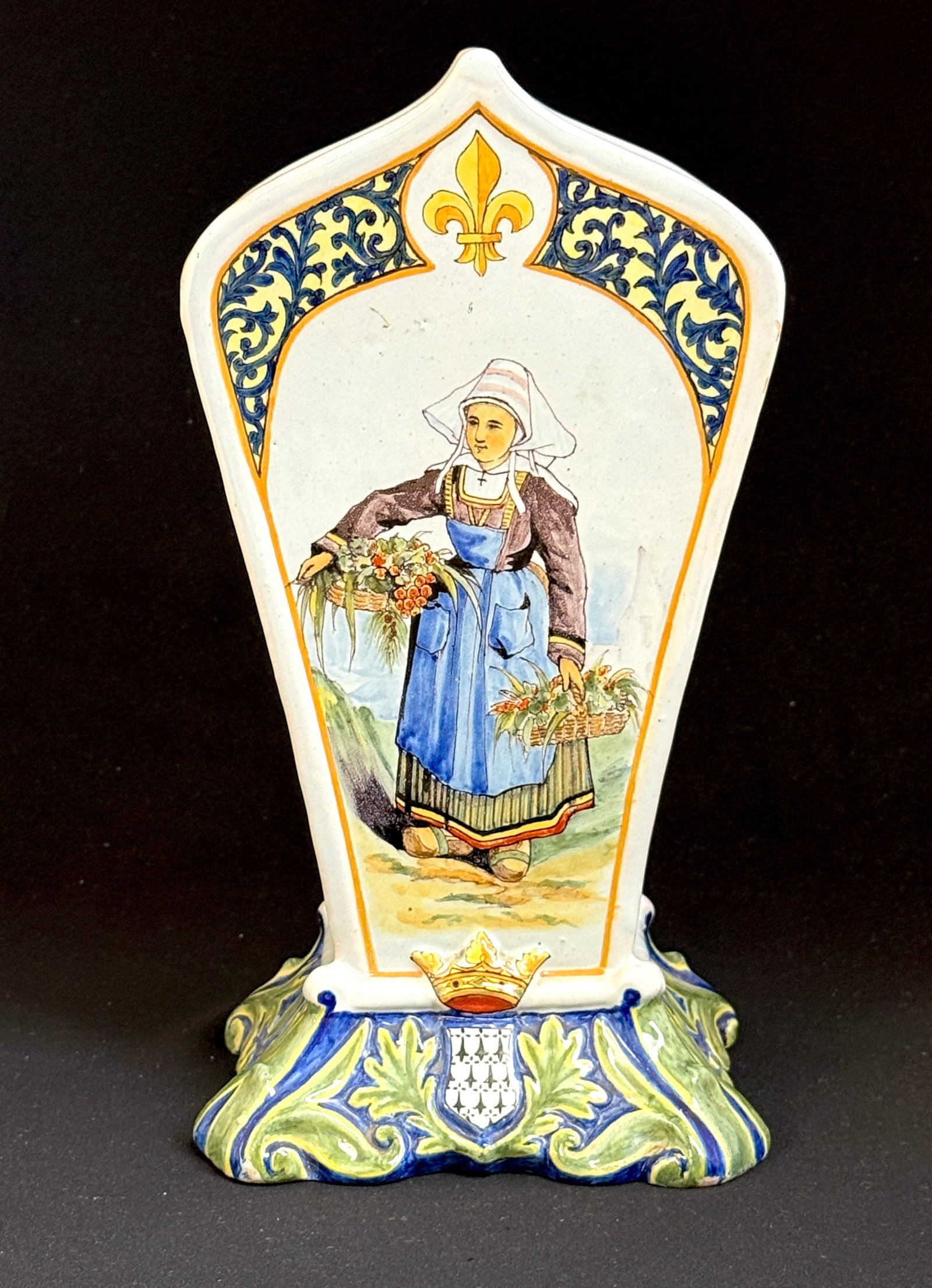 Porquier Beau Footed Vase: Porquier Beau footed saintin vase circa 1875-1905, decorated with Blason of Quimper "Marchande de fruits" Bretonne selling fruit with florals on the back, ht 11". LITERATURE: Tome II Encylopedie des