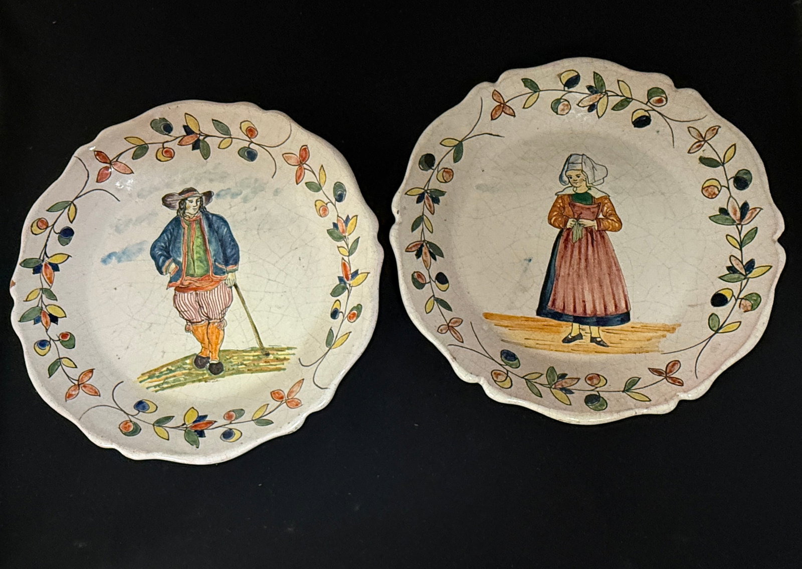 2 Malicorne Plates: 2 Malicorne deep plates including a Bretonne holding her knitting and a nicely dressed Breton leaning on a walking stick, diameter 10" circa 1895-1920. CONDITION: Quimper has propensity to have minor