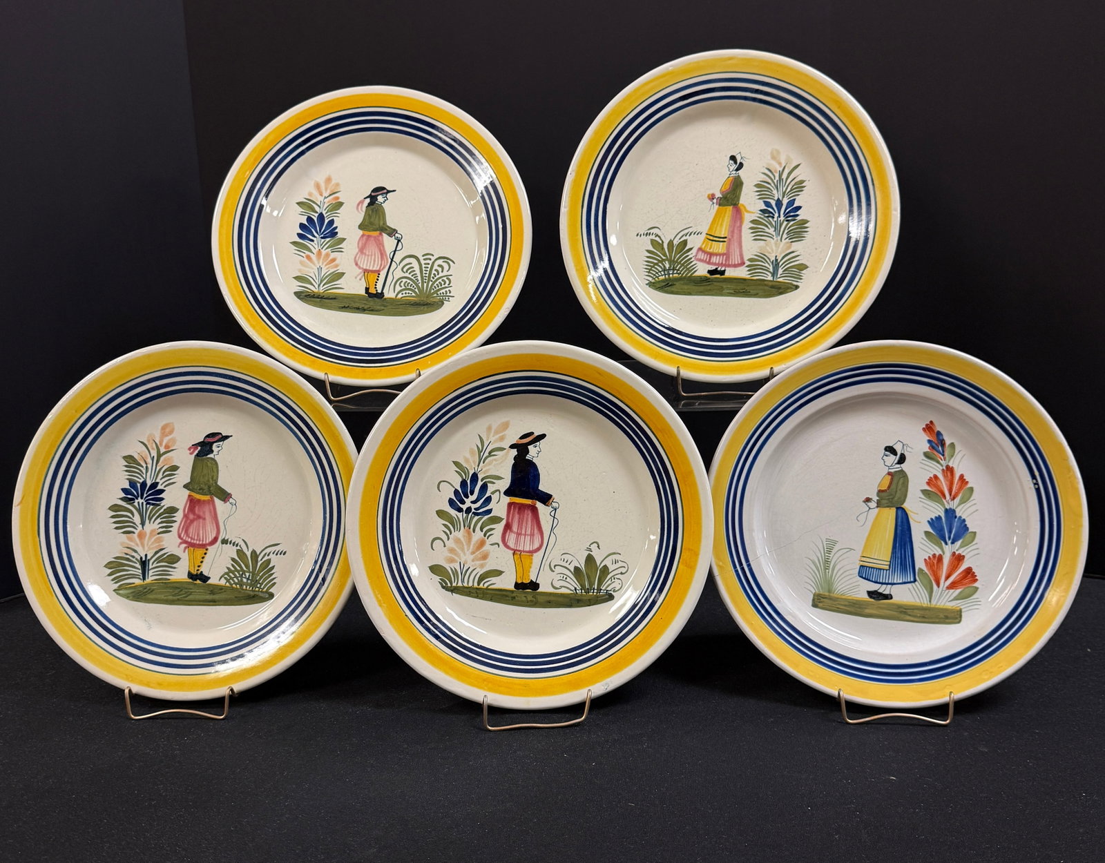 5 HenRiot Quimper Plates: 5 HenRiot Quimper plates with yellow and blue banding and Bretons; diameter 10 1/2" circa 1922-1984. CONDITION: one with crack see picture. Quimper has propensity to have minor chips, glaze loss/wear
