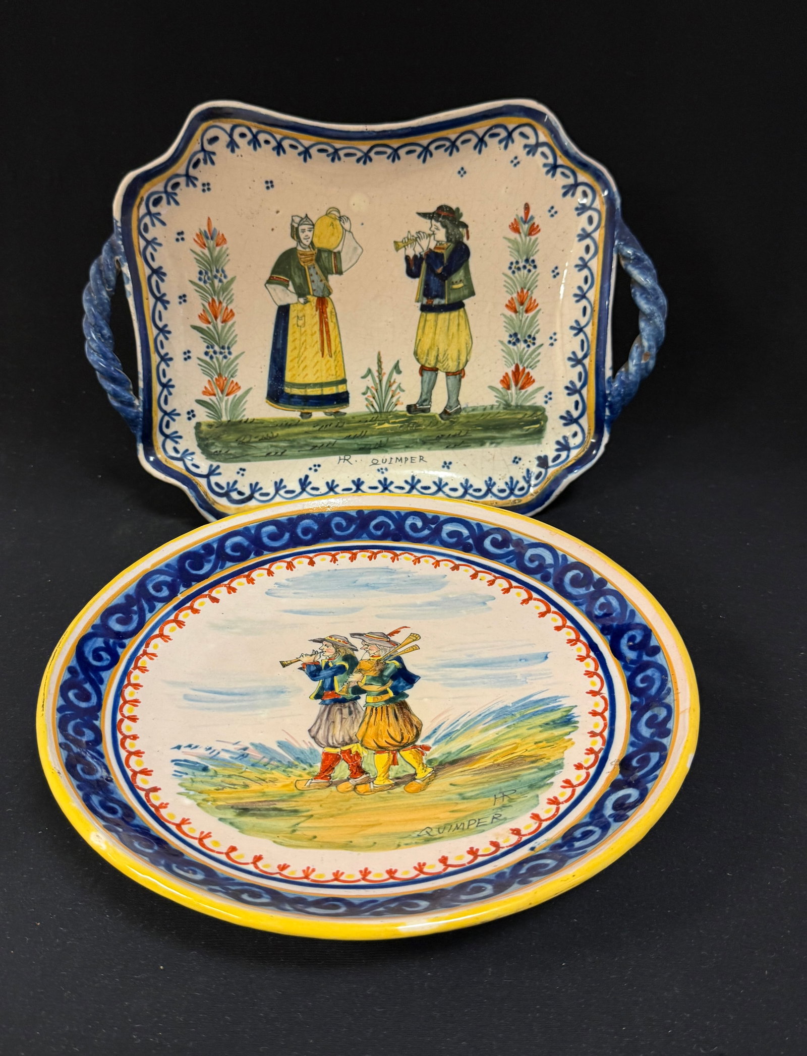 2 HR Quimper Items: HR Quimper rectangular bannette with rope handles and scene of Breton couple, 2 la touch? floral sprays and 4 dot motif together with a cake stand with Bretons playing a bombarde and biniou; largest