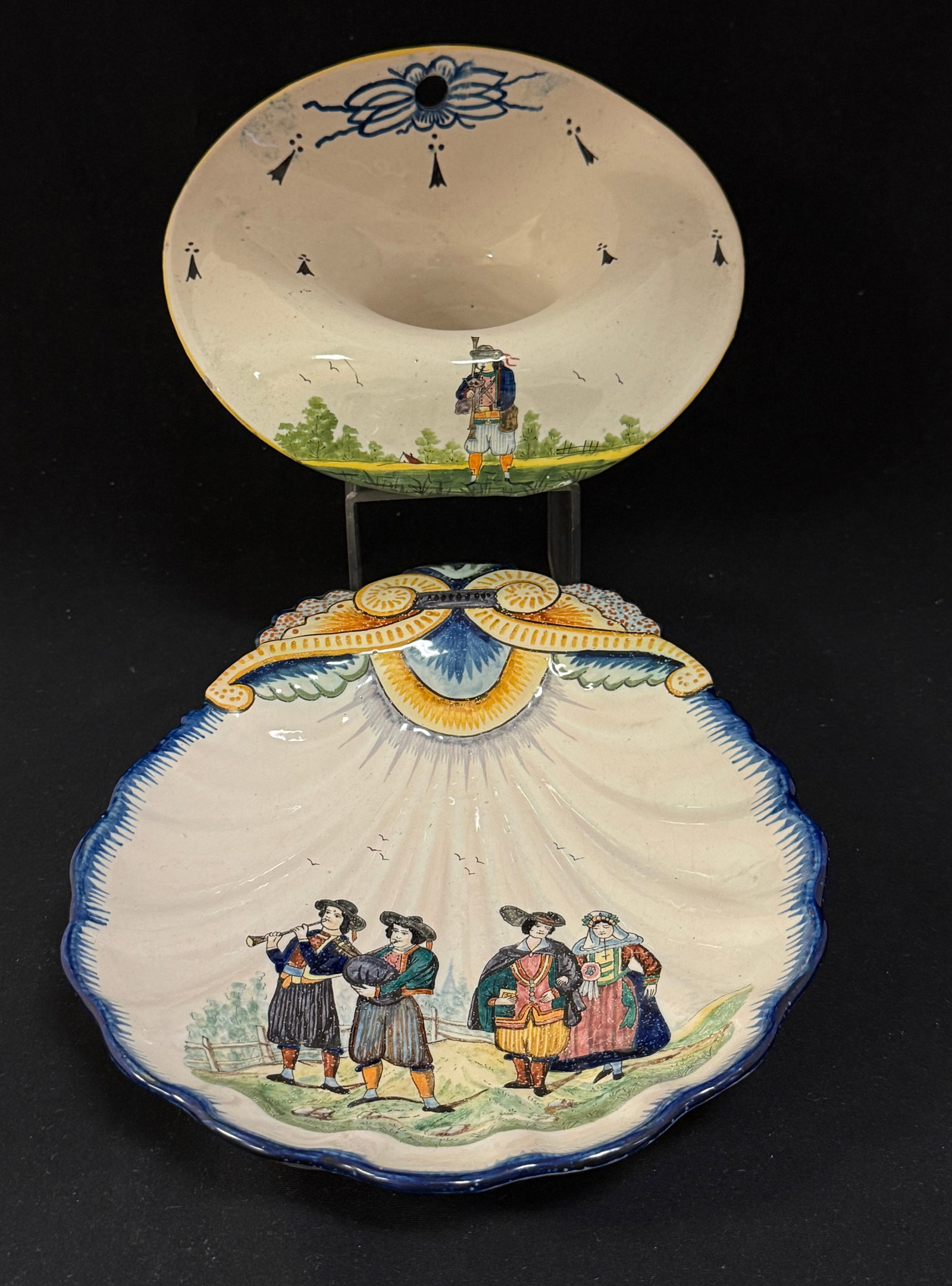 2 HB Items: 2 HB items 1) footed shell dish with newlywed couple and musicians 2) hat form wall pocket with Breton playing a biniou with countryside background and ermine tail motif; longest 10" circa 1883-1904. 