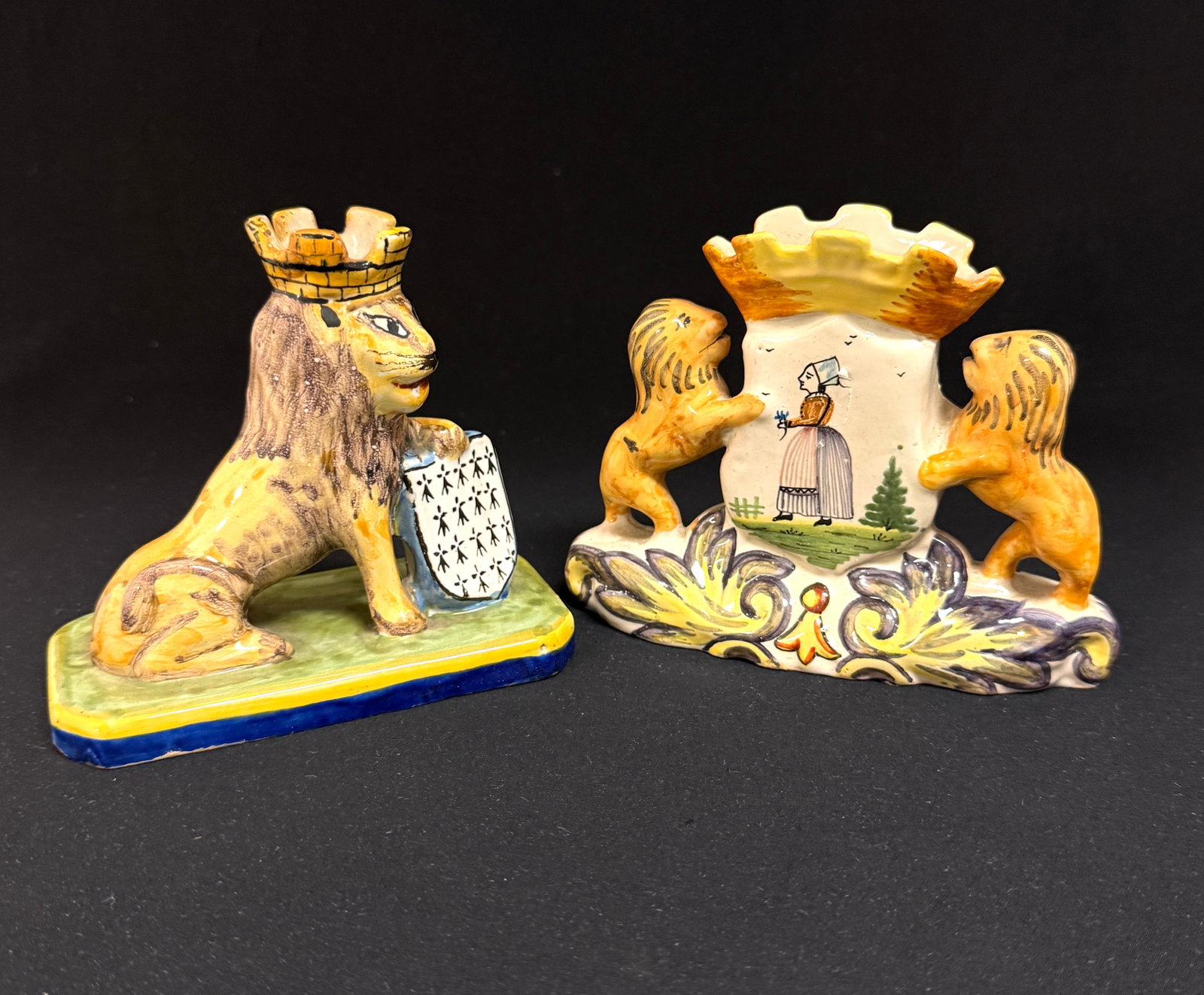 2 French Faience Items: 2 French faience items 1)AP figural lion with Blason of Brittany 2) HB spill vase with 2 lions flanking Blason of Quimper on one side and a Bretonne on the other; largest ht. 4 1/4" circa 1883-1905.