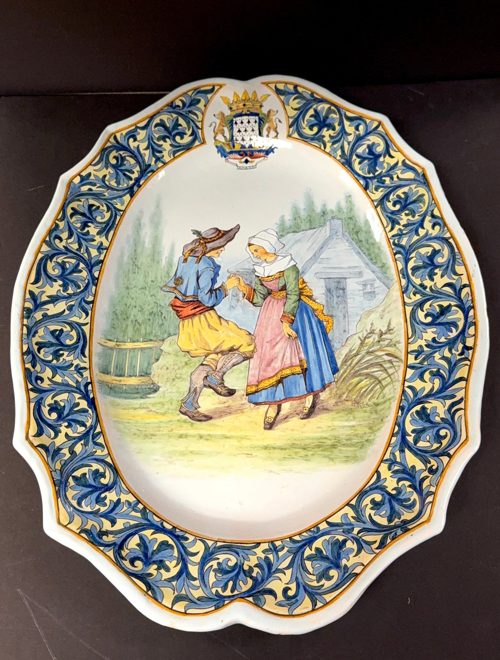 Large Porquier Beau Platter: Large oval Porquier Beau platter with Blason of Brittany, d?cor riche border and beautifully painted Breton and Bretonne dancing; length 21 1/4". LITERATURE: Tome II page 462 Planche No 155 "Danse