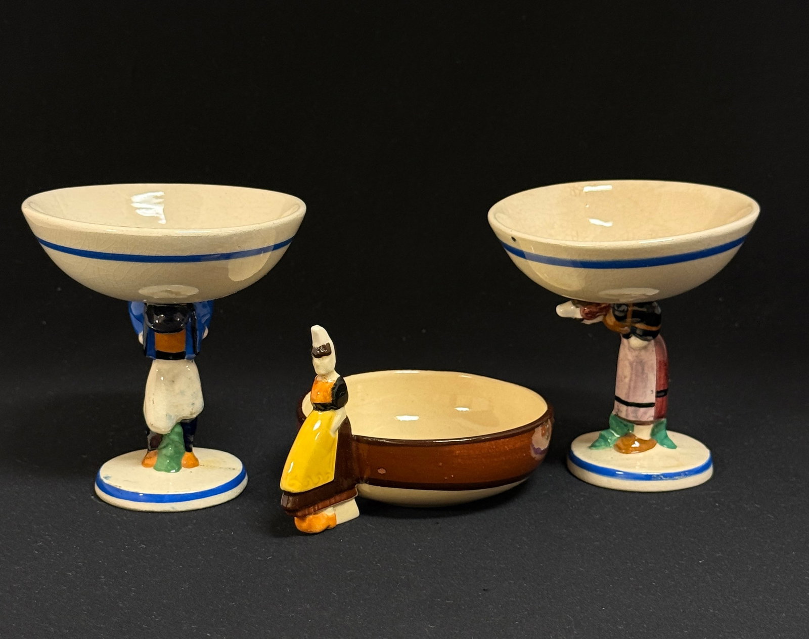 3 Charles Maillard Items: 3 Charles Maillard items 1) 2 HenRiot Quimper figural stemmed cups 2) small bowl with figural Bretonne; tallest 4 1/2" circa 1930-1950. CONDITION: small bowl has small chip on rim. Quimper has