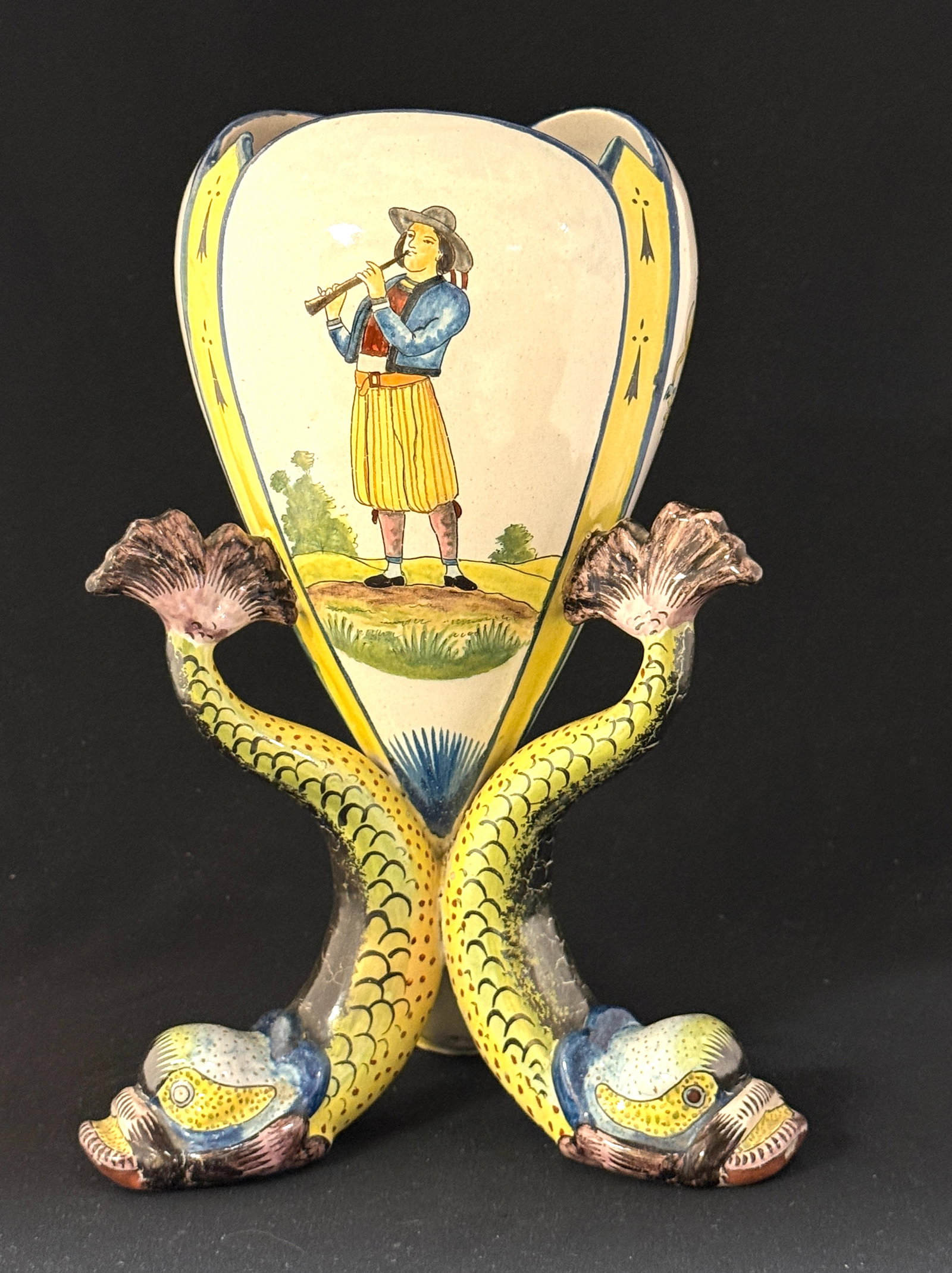 HB Quimper French Faience Vase: HB Quimper French faience vase supported by 3 colorful dolphin, 3 panels are finely decorated with the Blason of Brittany a finely dressed Breton playing a biniou and a young Breton playing a