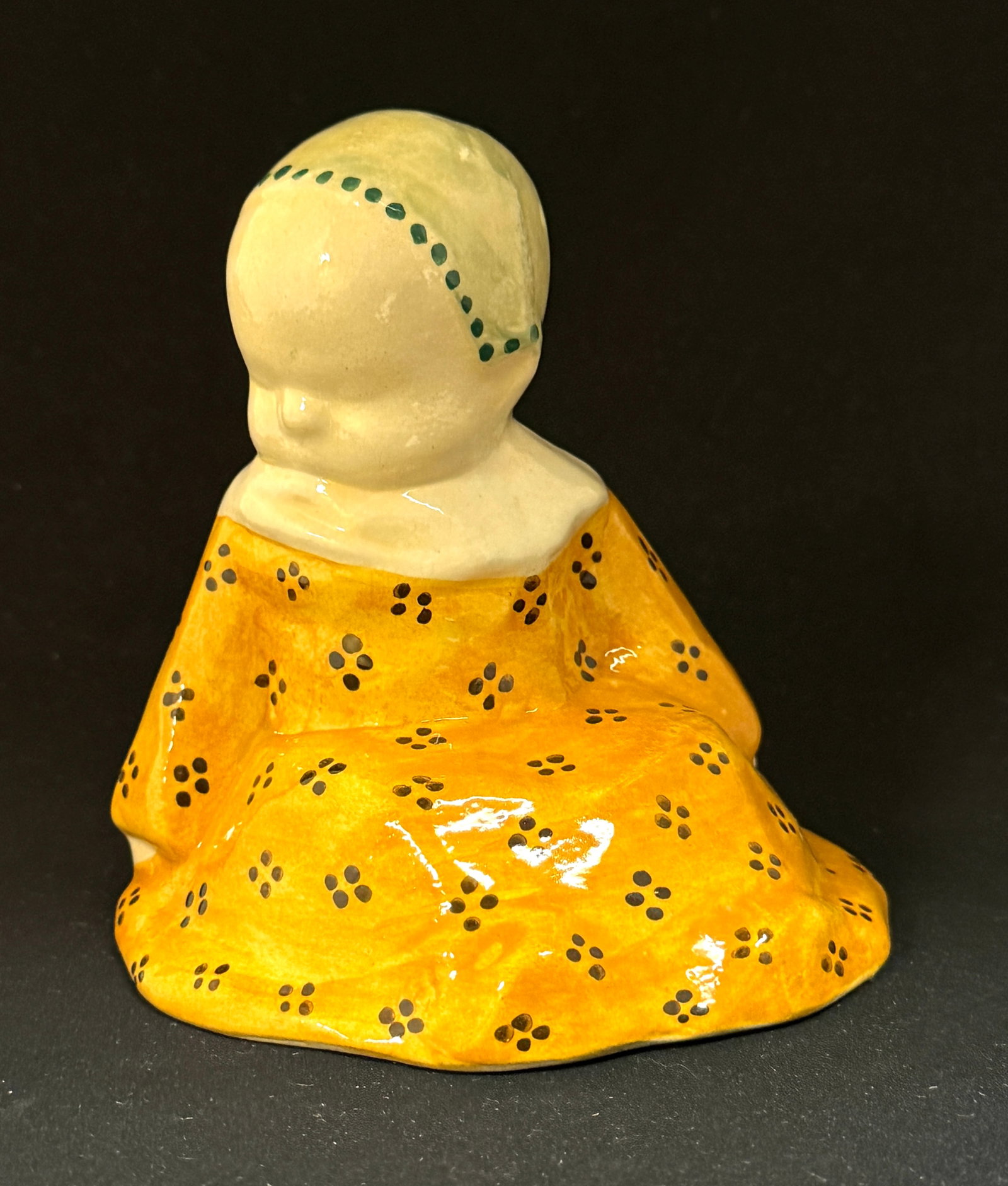 Berthe Savigny Figural: HB Quimper Berthe Savigny "Bebe" in soft tangerine toned dress and wearing a pastel seafoam bonnet; ht. 5 1/2" circa 1930. CONDITION: Quimper has propensity to have minor chips, glaze loss/wear and