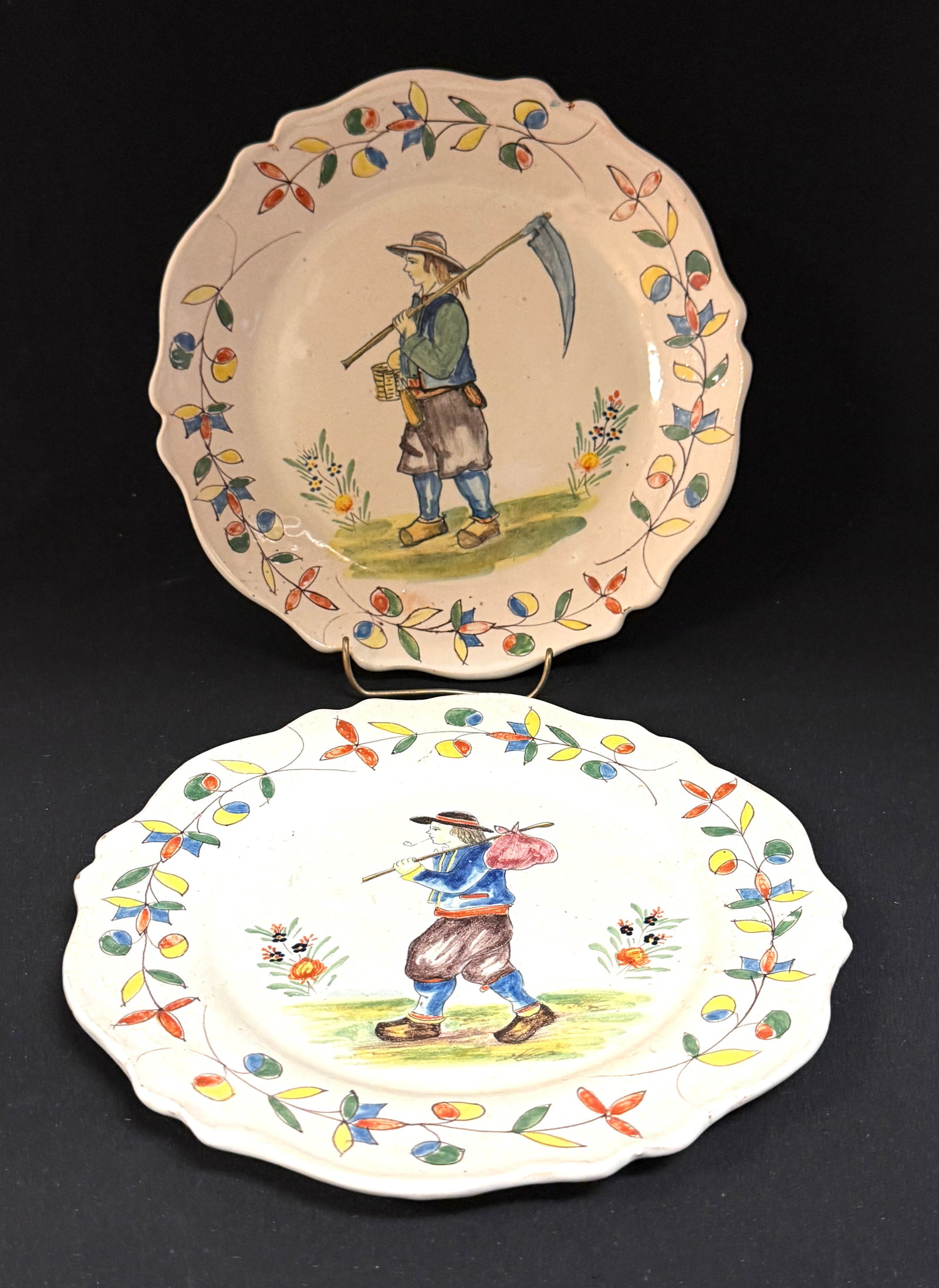 Pouplard Beatrix Malacorne Plates: 2 Pouplard Beatrix Malicorne plates one with Breton carrying knapsack and the other with a Breton carrying a scythe; diameter 9 1/4" circa 1895-1920. CONDITION: Quimper has propensity to have minor