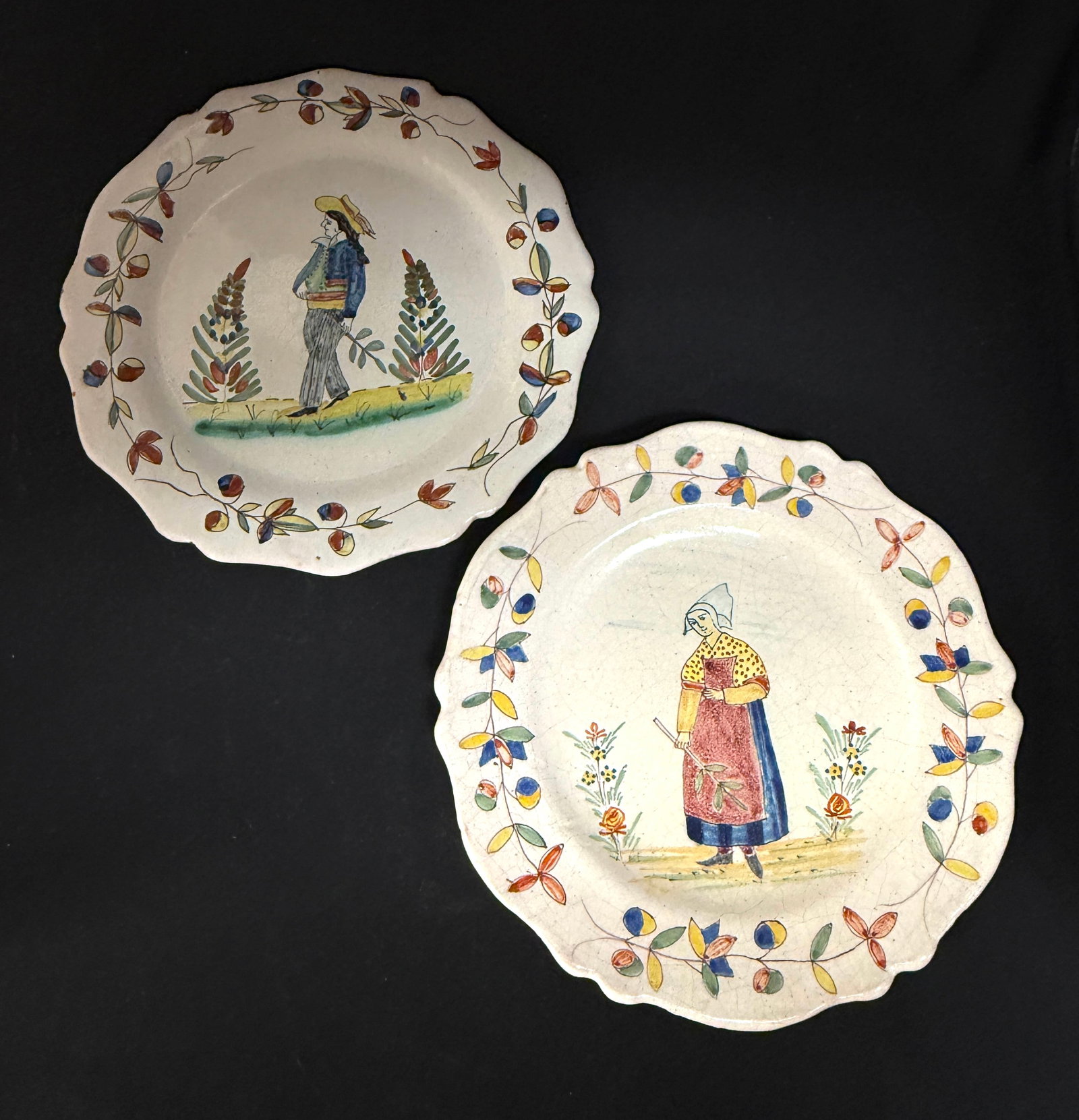 2 Malicorne Plates: 2 Malicorne plates one with a Bretone the other Pouplard Beatrix holding twigs; diameter 9 1/2" circa 1895-1920. CONDITION: Quimper has propensity to have minor chips, glaze loss/wear and crazing.