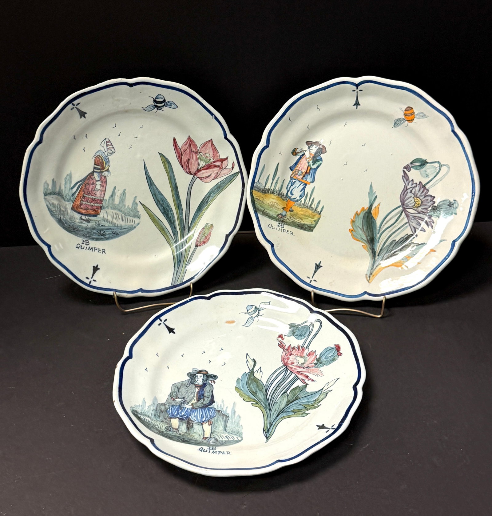 3 HB Quimper Botanical Plates: 3 HB Quimper botanical plates with Bretons playing biniou and bombarde in typical dress with bees, seagulls, ermine tail. Glaze has slight blue gray color used by Porquier Beau; diameter 9 1/4" circa