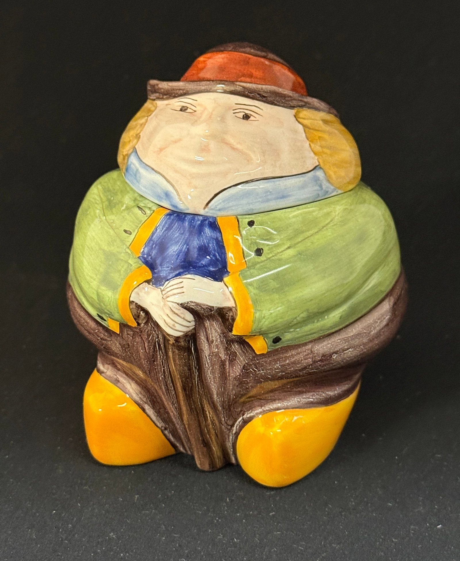 HB HenRiot Quimper Lidded Jar: HB HenRiot Quimper "Bonhomme" lidded jar, vibrant green jacket, holding a cane and wearing sabots; ht. 4 1/2" circa after 1984. CONDITION: Quimper has propensity to have minor chips, glaze loss/wear